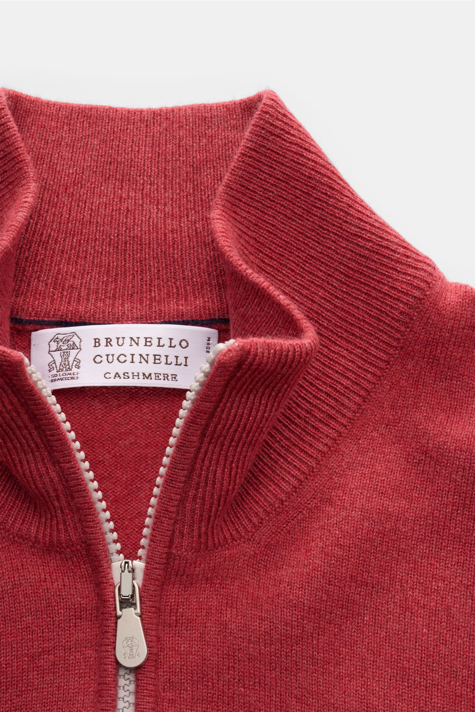Brunello Cucinelli Cashmere Troyer hellrot shown in close-up from above, featuring a soft light red knit with a half-zip troyer collar, fine stitch pattern, narrow contrast edges, and flexible ribbed cuffs. Sportives Freizeit-Essential made in Solomeo: