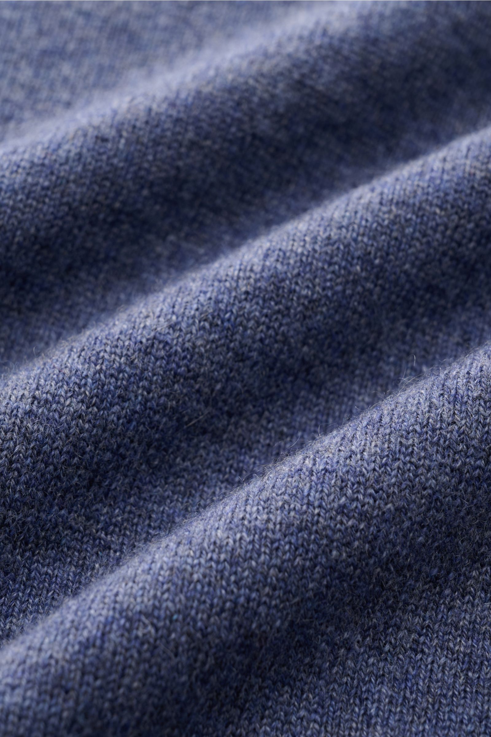 Close-up front view of the finely knitted fabric texture of the Brunello Cucinelli Cashmere Troyer blau meliert, made of pure cashmere with a very soft feel.

Description: Sportives Freizeit-Essential made in Solomeo: Der Troyer aus reinem Cashmere von