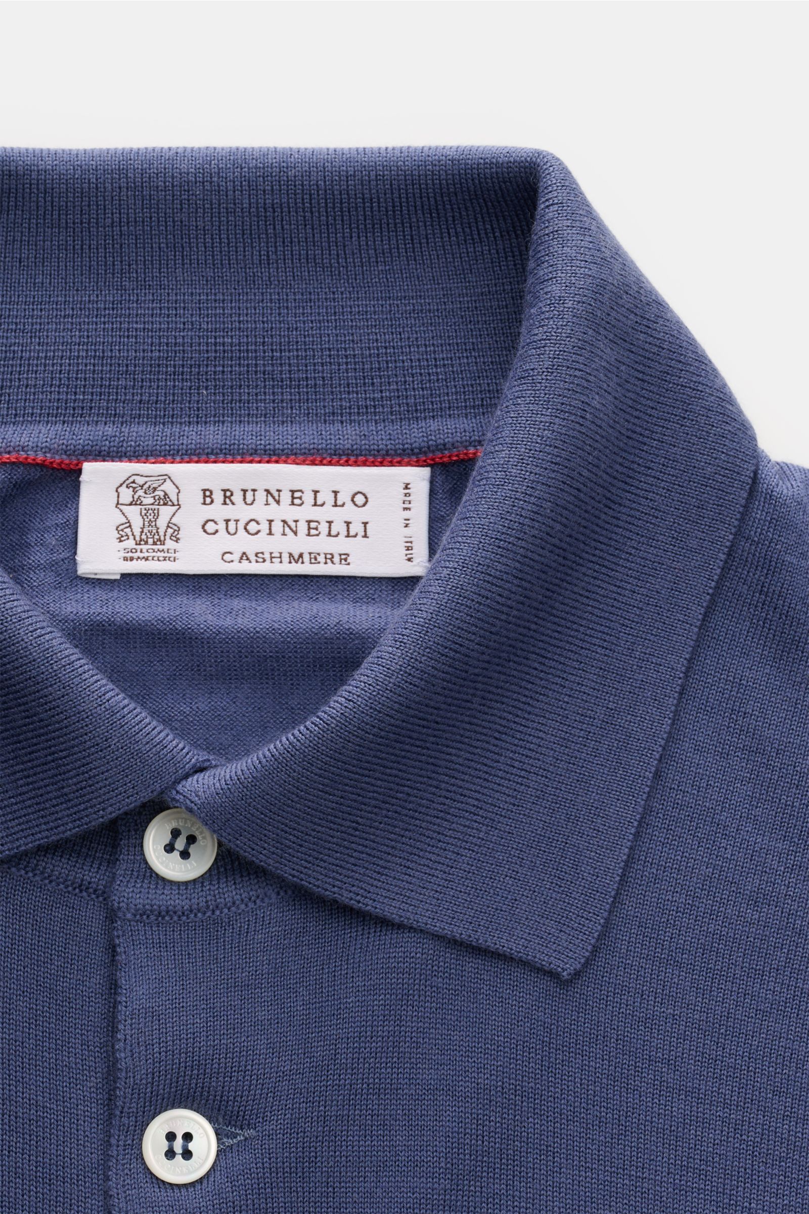 Close-up front view of a Brunello Cucinelli Strickpolo blau, showcasing its classic polo collar, three-button placket, and fine knit texture. Luxus, den Sie sofort spüren: Dieses zeitlose Poloshirt von BRUNELLO CUCINELLI besticht durch seine angenehm l