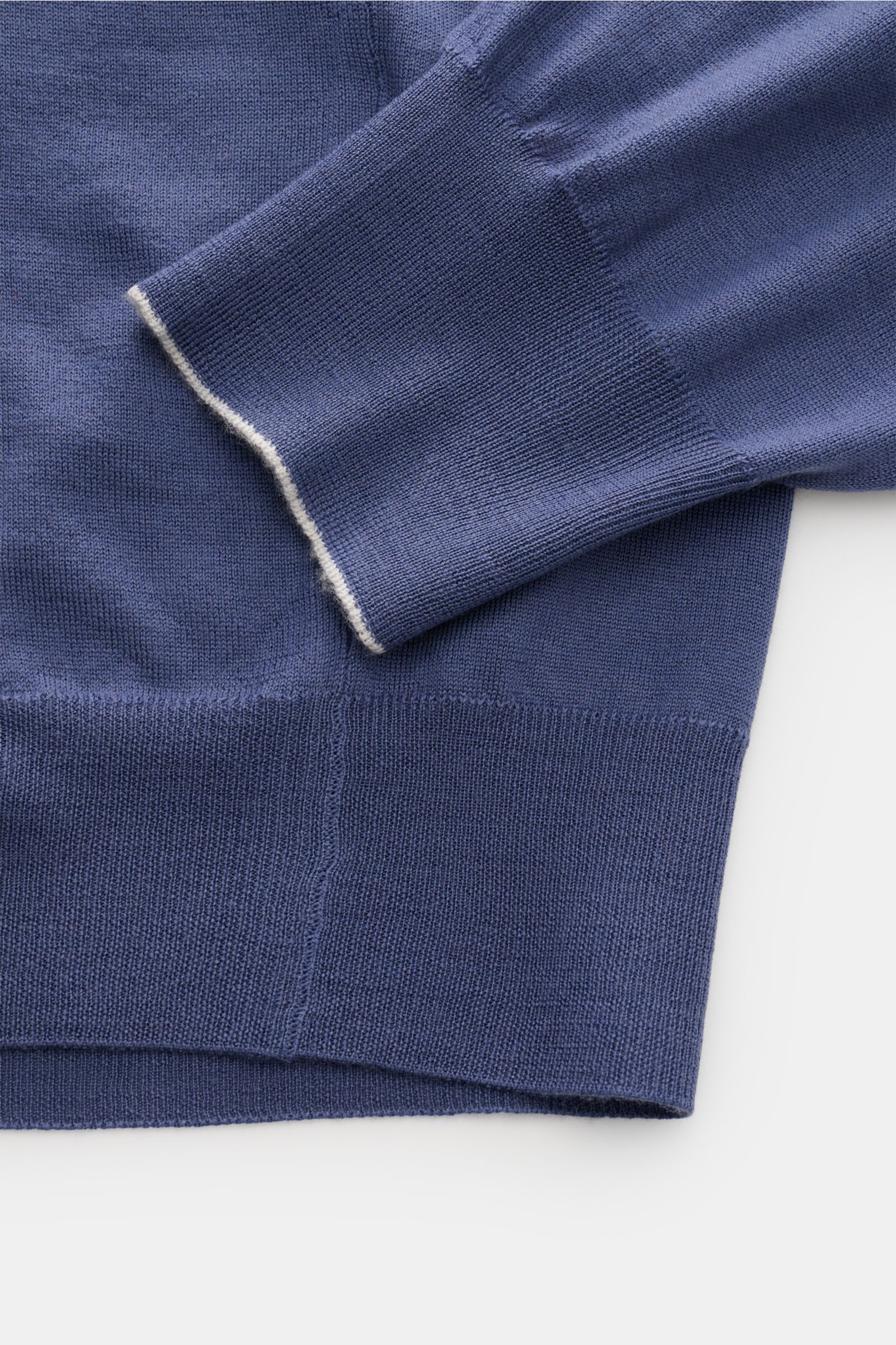 Close-up side view of the sleeve and hem of the Brunello Cucinelli Strickpolo blau, a blue knit polo shirt with soft ribbed cuffs and fine stitching.

Luxus, den Sie sofort spüren: Dieses zeitlose Poloshirt von BRUNELLO CUCINELLI besticht durch seine a