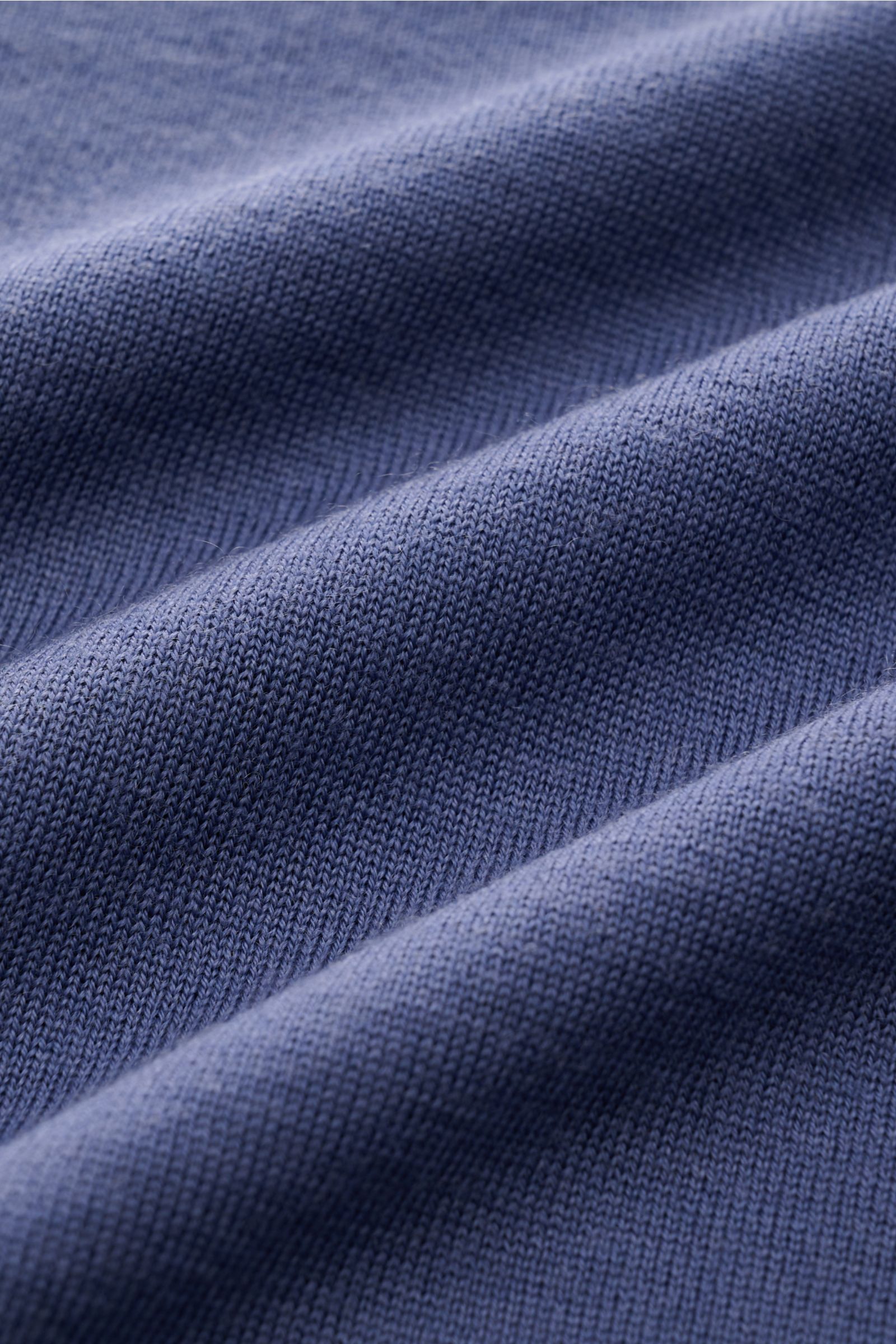 Close-up view of the fabric texture of the Brunello Cucinelli Strickpolo blau, showing its soft knit in a blue mix of wool and cashmere. Luxus, den Sie sofort spüren: Dieses zeitlose Poloshirt von BRUNELLO CUCINELLI besticht durch seine angenehm leichte S