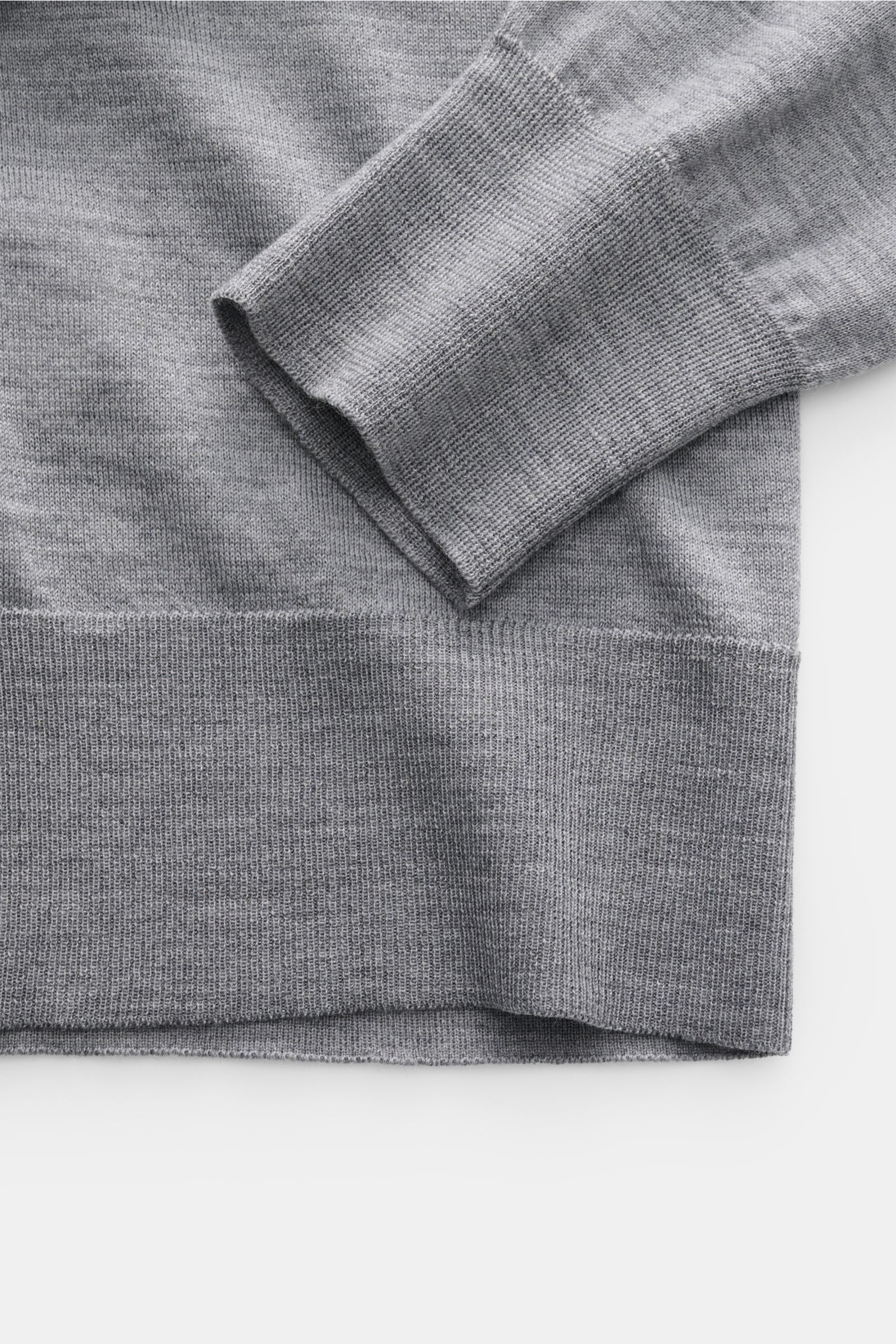 Nahaufnahme des Ami Paris Merino Cardigan grau meliert von oben, Detail der weichen reinen Merinowolle, Rippbündchen und feinem Strickbild.