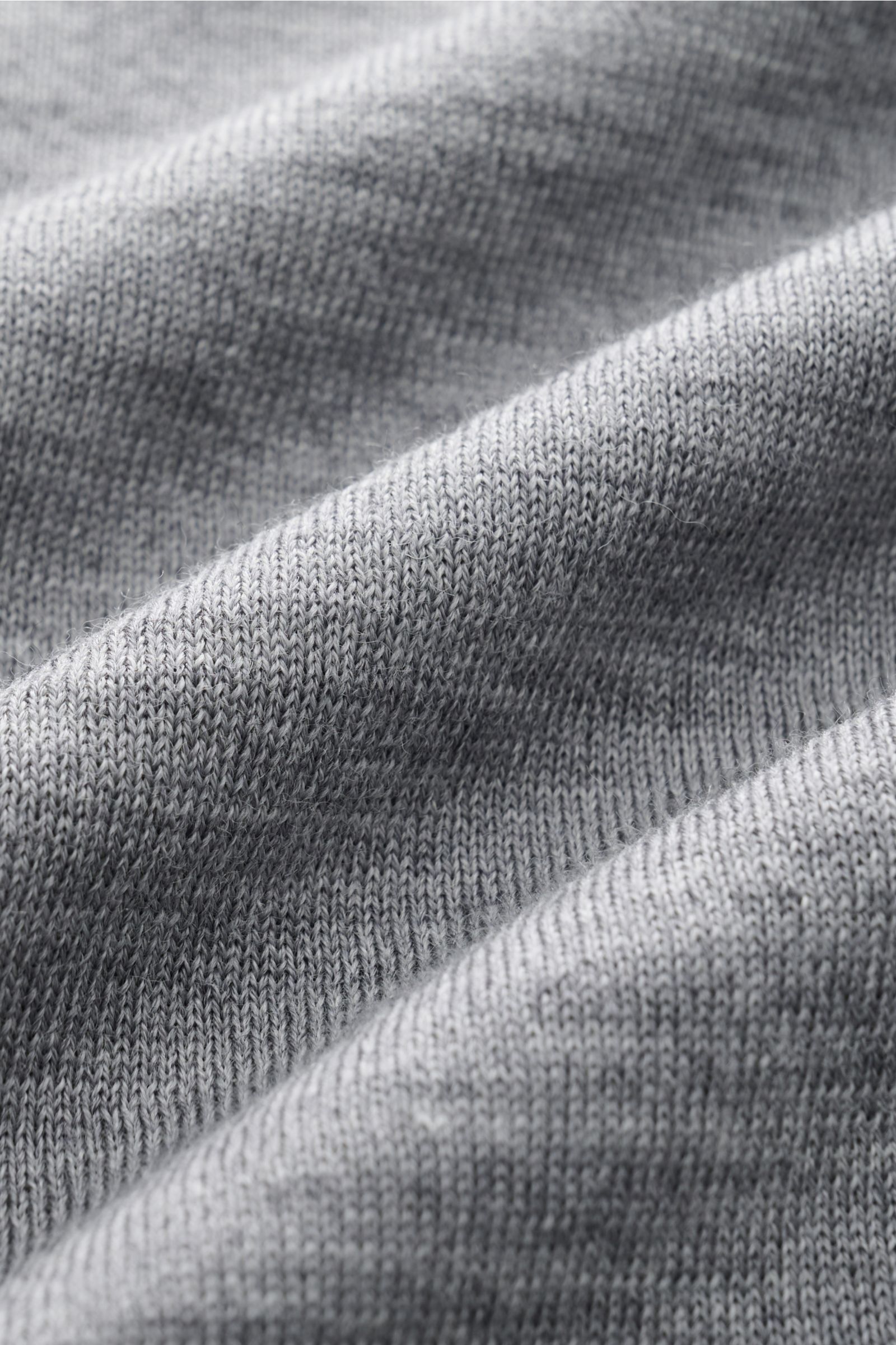 Ami Paris Merino Cardigan grau meliert in Nahaufnahme, zeigt feines Strickbild aus weicher reiner Merinowolle, detailreiche Stoffstruktur.