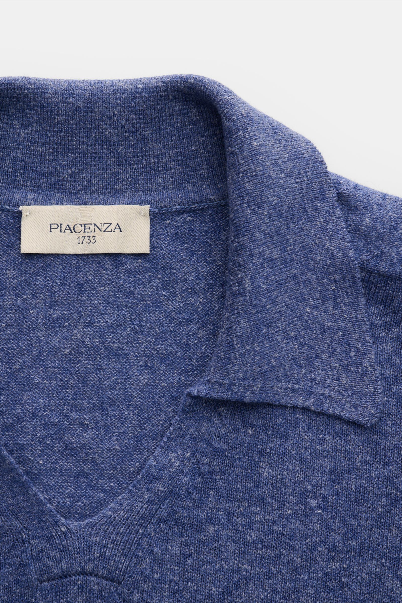 Piacenza 1733 Strickpolo rauchblau meliert, Nahaufnahme von oben, weicher Cashmere-Leinen-Mix, feines Strickbild, klassischer Polokragen, offene Kragenleiste, Rippbündchen, Oversized Fit.