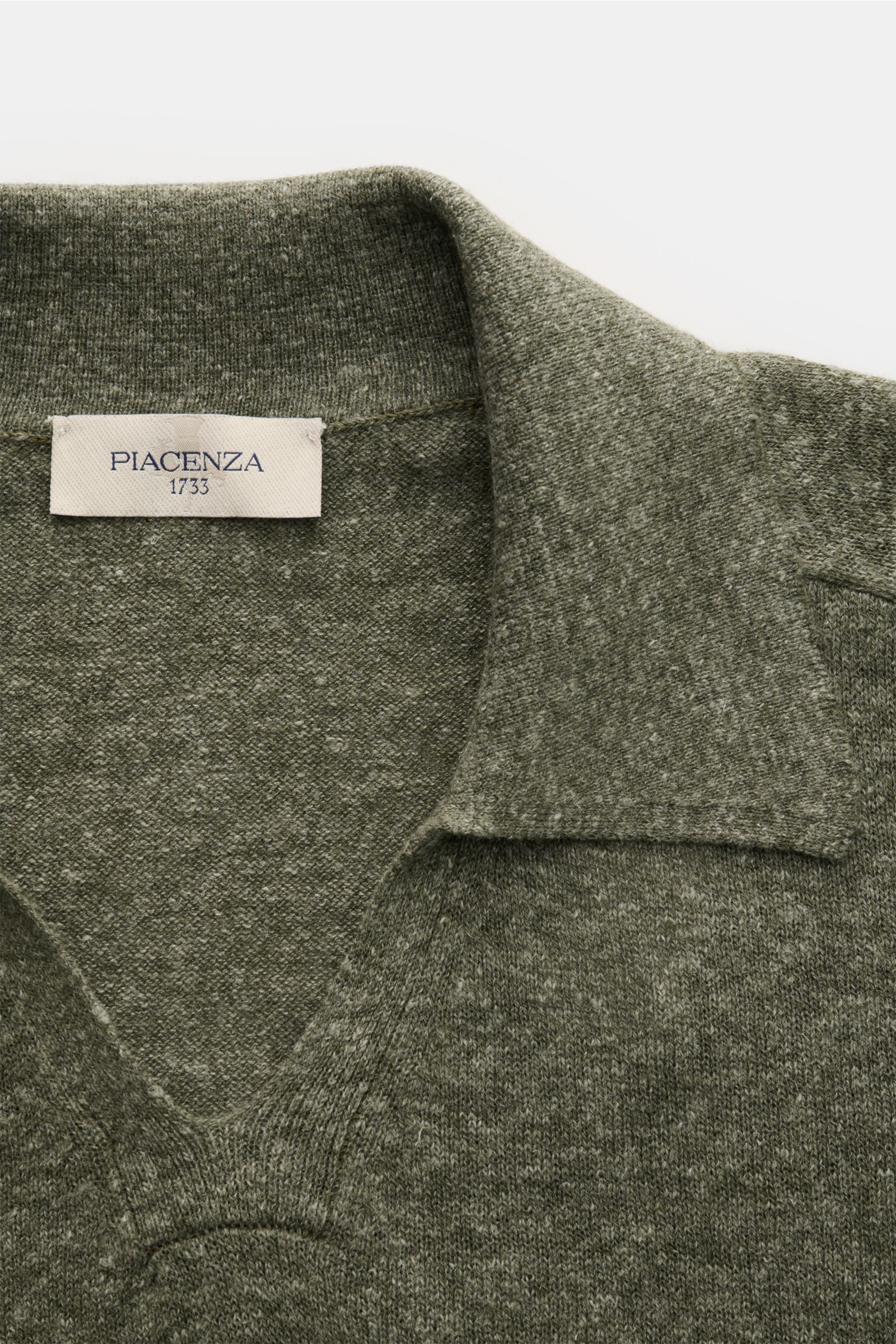 Piacenza 1733 Strickpolo dunkelgrün meliert, Nahaufnahme von offenem Polokragen mit feinem Strickbild, weichem Griff, Oversized Fit, Rippbündchen.