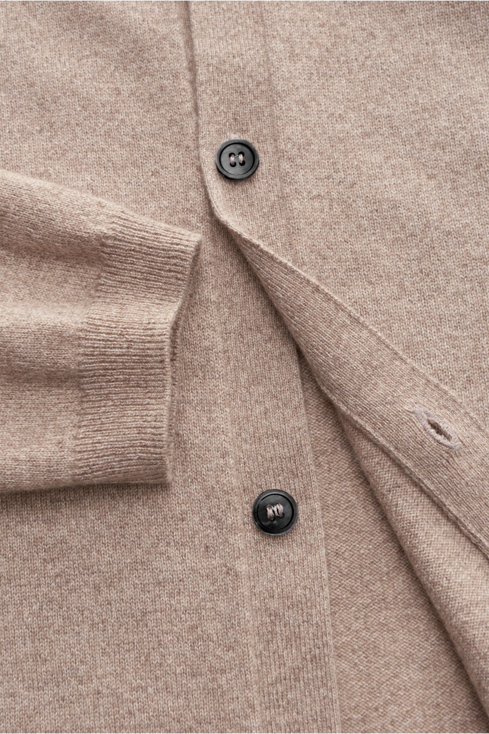 Close-up top-down view of von Braun Cashmere knit shirt beige showing fine knit fabric, black buttons, ribbed cuff, and smooth button placket.

Luxurious winter essential: This VON BRAUN knit shirt in the finest Mongolian cashmere has a timeless design