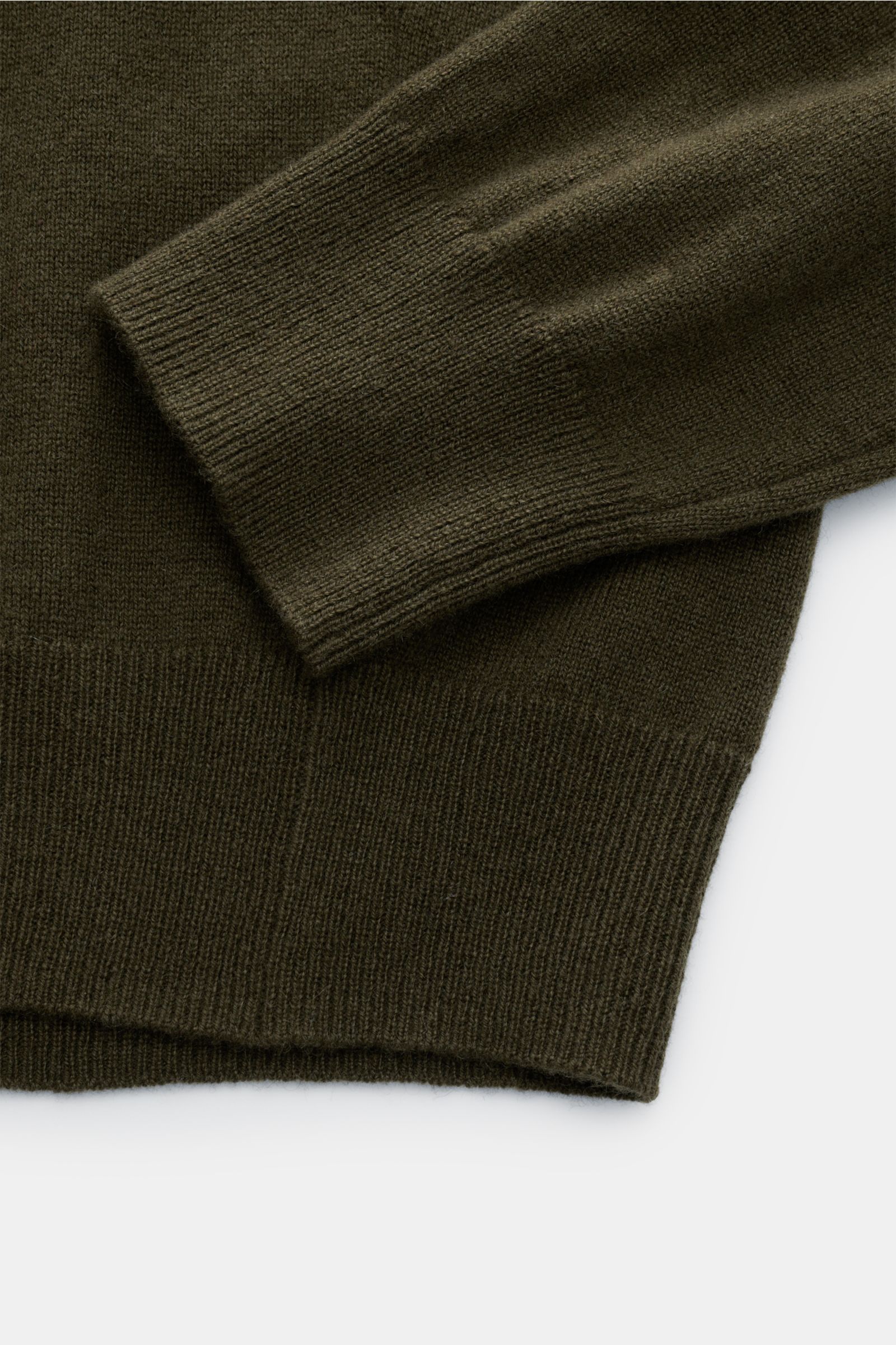 Nahaufnahme des von Braun Cashmere Troyer oliv, zeigt feines Strickbild, weichen Griff, flexible Rippbündchen und Slim Fit, seitliche Perspektive.