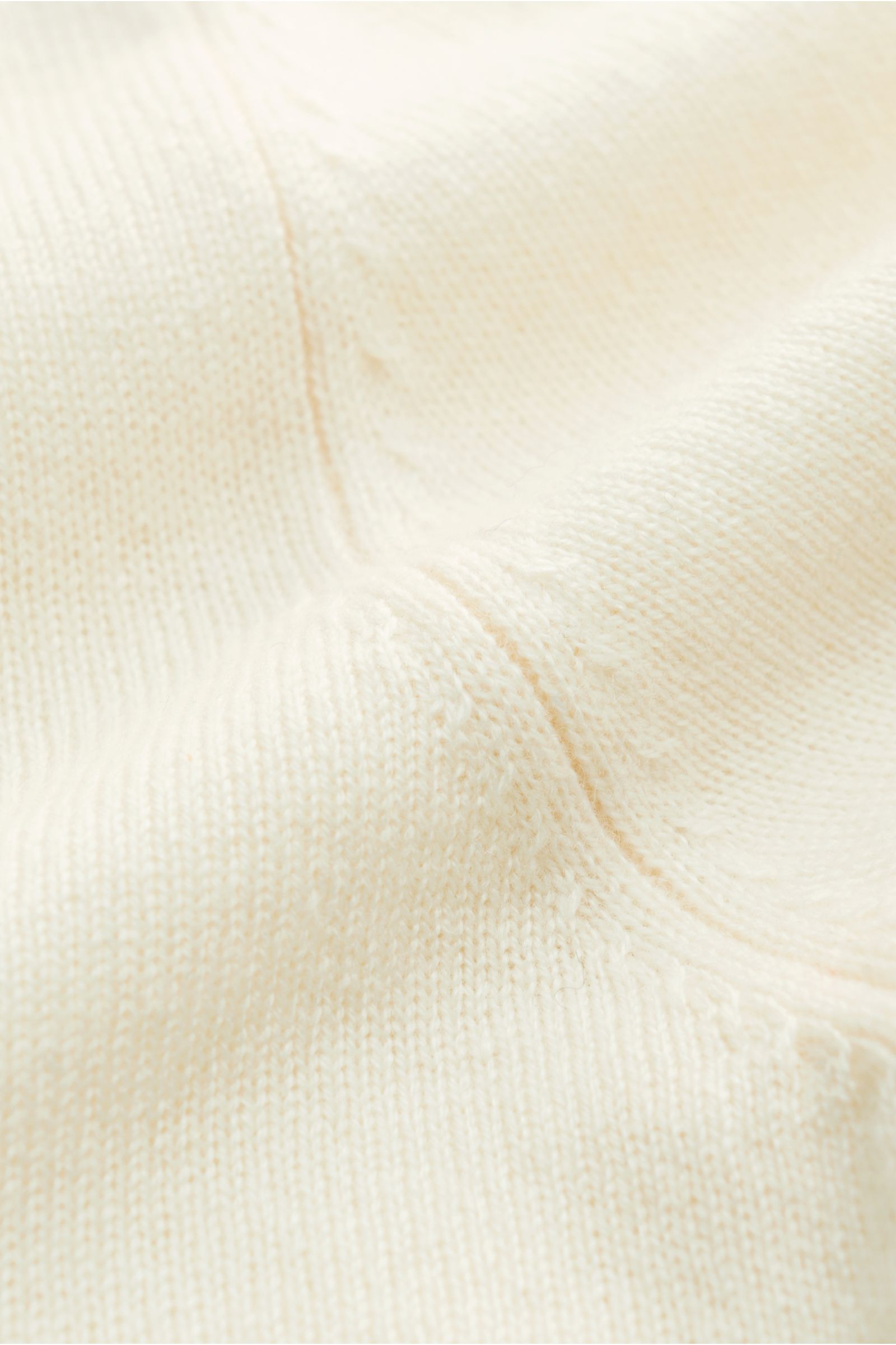 von Braun Cashmere Troyer creme, Nahaufnahme des feinen Strickbilds und der weichen, hochwertigen Cashmere-Mongolei-Faser, Slim Fit, Troyerkragen mit Zipper, flexible Rippbündchen, Perspektive von oben schräg.