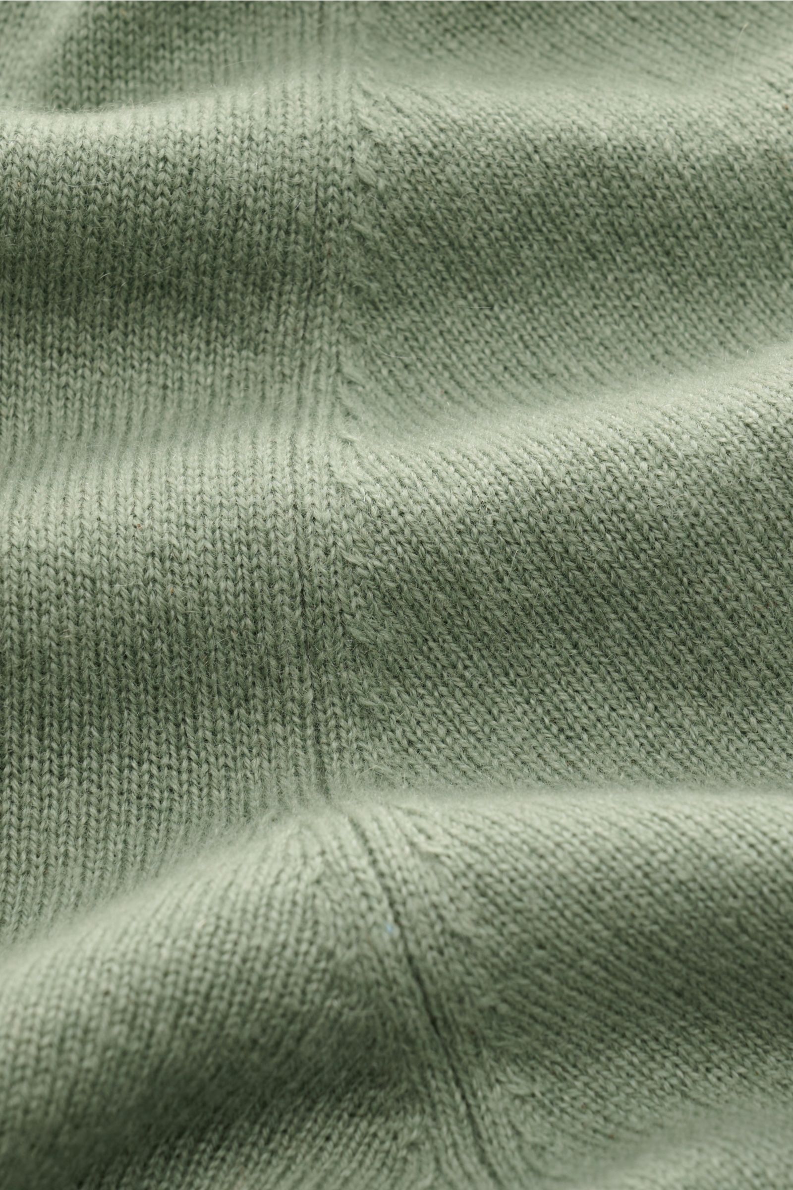 Nahaufnahme des feinen Strickbilds eines von Braun Cashmere Troyer salbei, gefertigt aus reinem, weichem Cashmere mit typischem Troyerkragen.