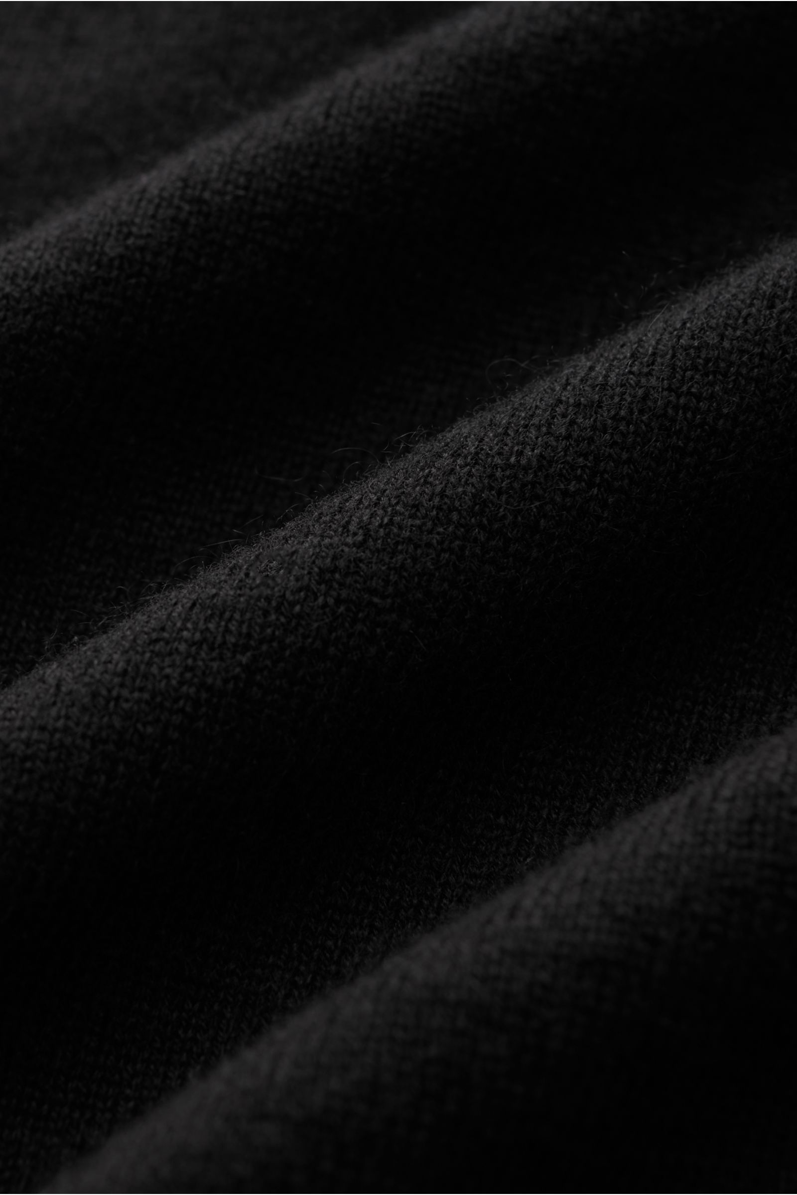 Nahaufnahme des feinen Strickbilds und weichen Griffs vom schwarzen von Braun Cashmere Troyer, Slim Fit mit Troyerkragen.