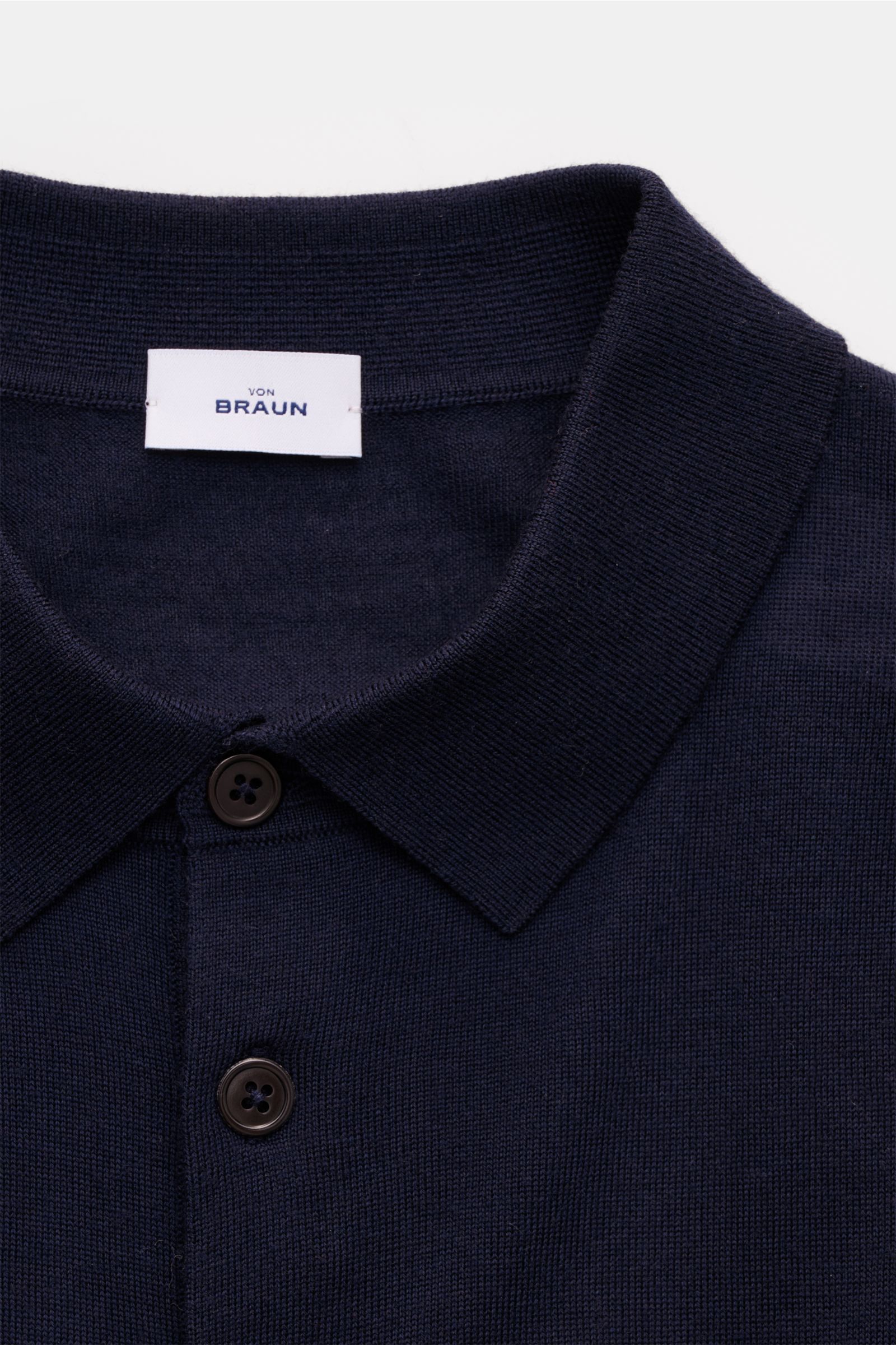 Nahaufnahme des von Braun Merino Feinstrickpolo navy mit schmalem Polokragen, glatter Drei-Knopf-Leiste aus reiner Merinowolle.