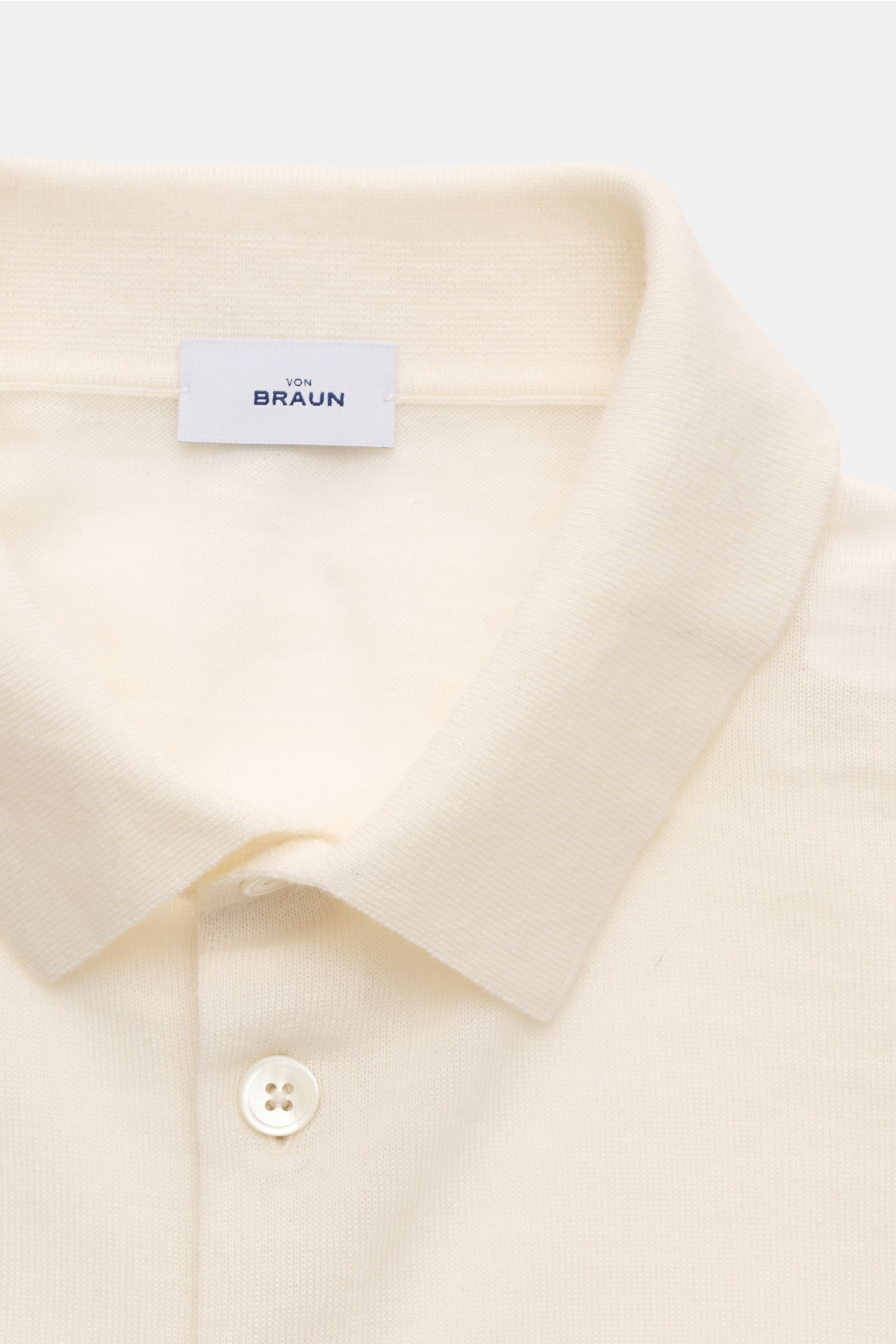 von Braun Merino Feinstrickpolo creme, Nahaufnahme von oben auf schmalen Polokragen, glatte Drei-Knopf-Leiste, reine Merinowolle, Slim Fit, sehr feines Strickbild, komfortable Rippbündchen, glatter, geschmeidiger Griff