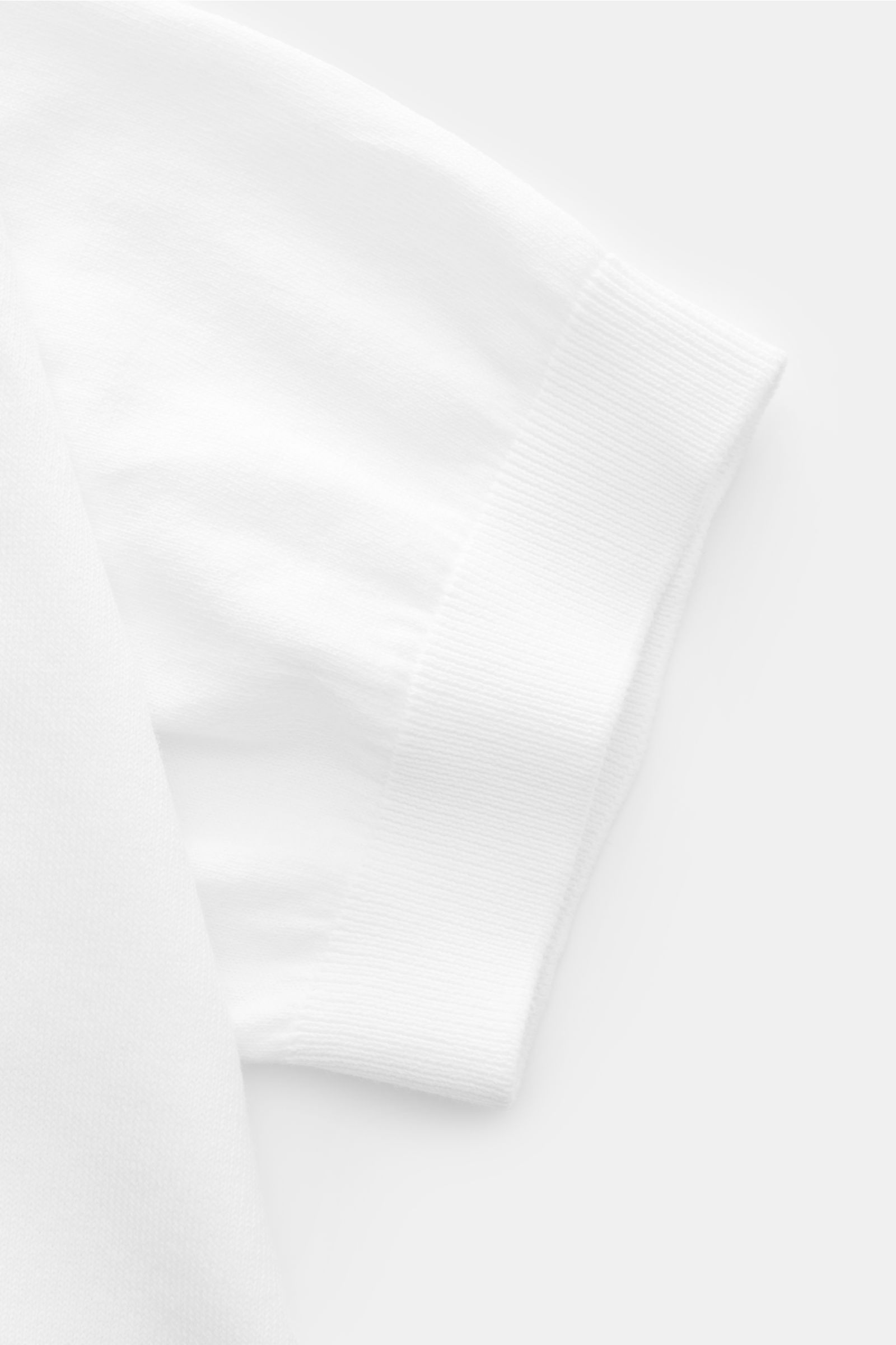 Close-up image of the sleeve cuff of the 04651/ A trip in a bag Short sleeve jumper 'Pima Cotton' white, showing fine knit and flexible ribbed bands. Made of pure Pima cotton, the short sleeve jumper 'Pima Cotton' by 04651 / A TRIP IN A BAG has an airy kn