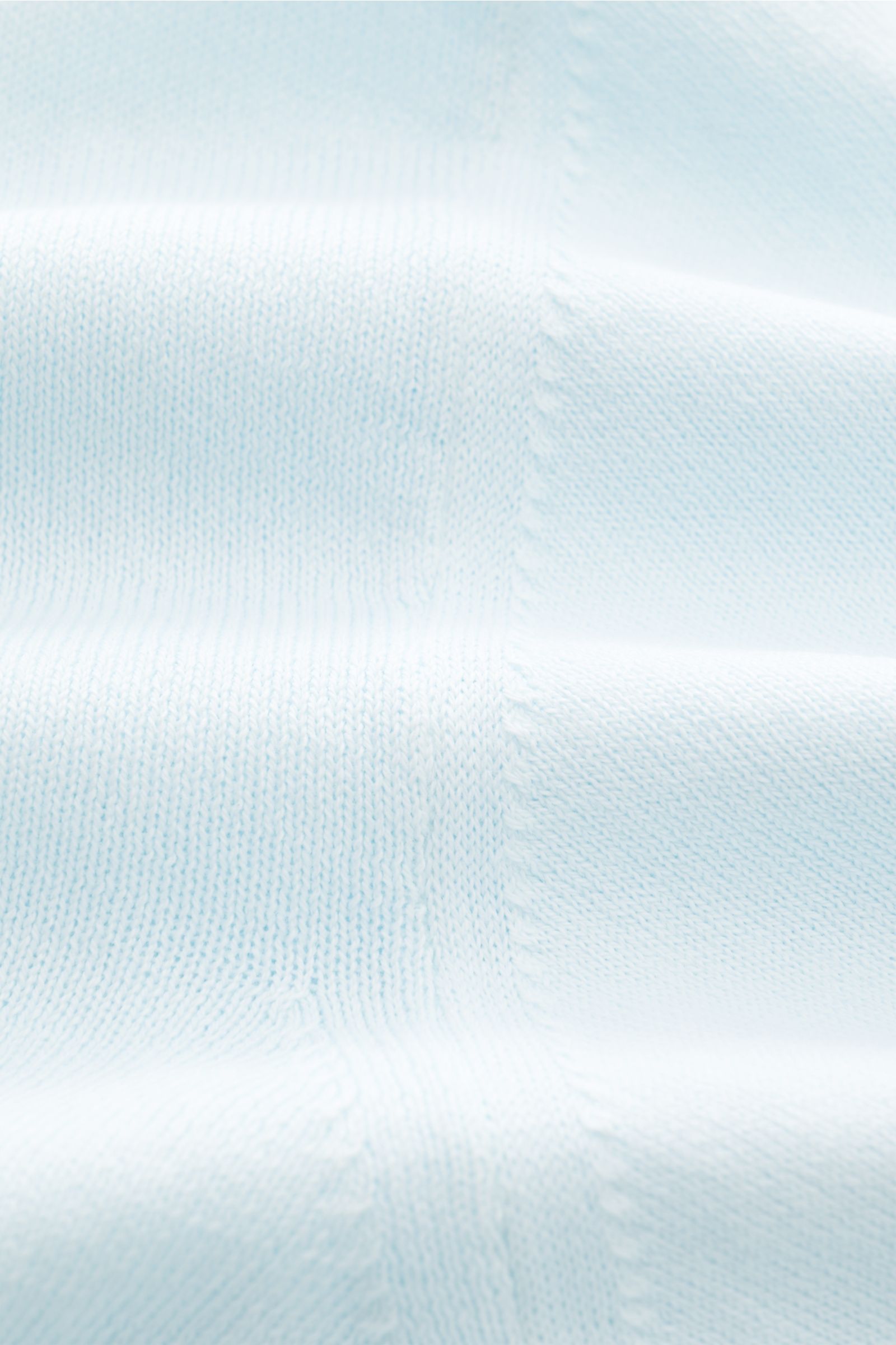 Close-up front view of 04651/ A trip in a bag Short sleeve jumper 'Pima Cotton' pastel blue showing its very fine knit texture. Made of pure Pima cotton, the short sleeve jumper 'Pima Cotton' by 04651 / A TRIP IN A BAG has an airy knit that makes it a goo