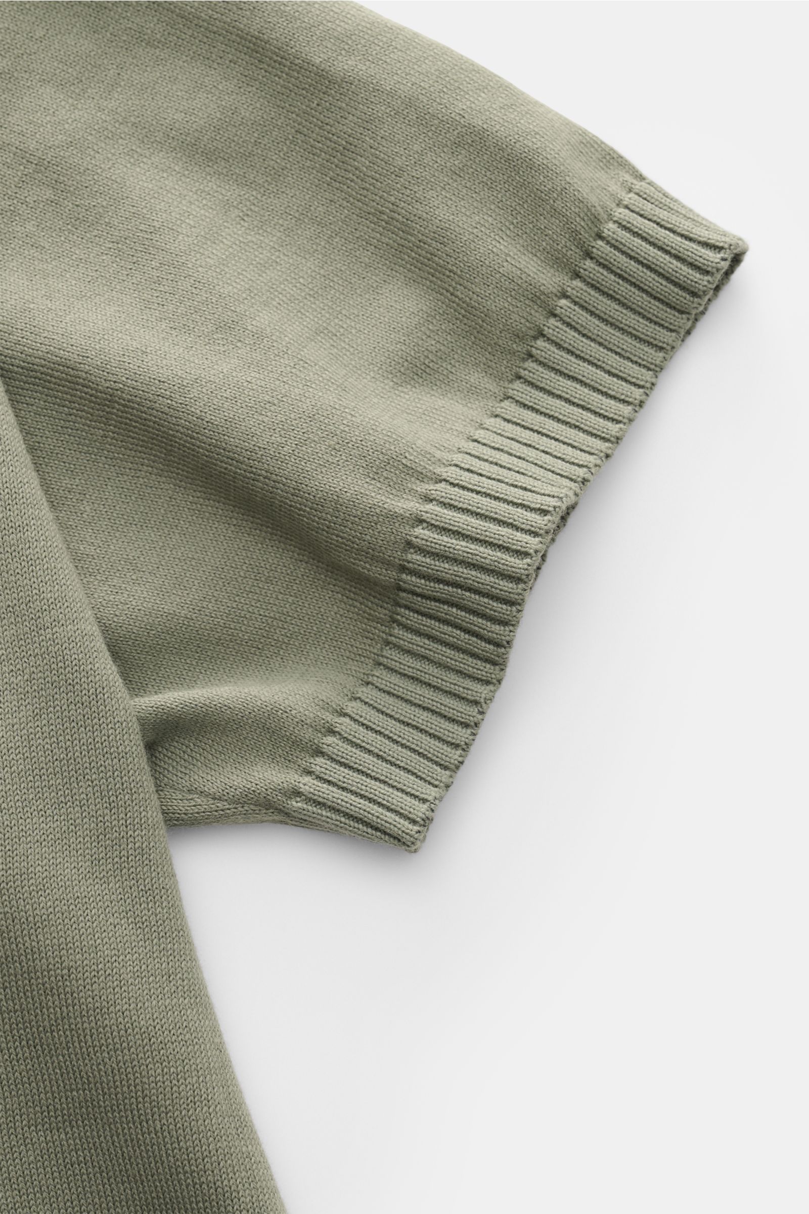 Nahaufnahme des Malo Kurzarm-Strickpolo salbei von oben, zeigt weiche reine Baumwolle, feines Strickbild und Rippbündchen.