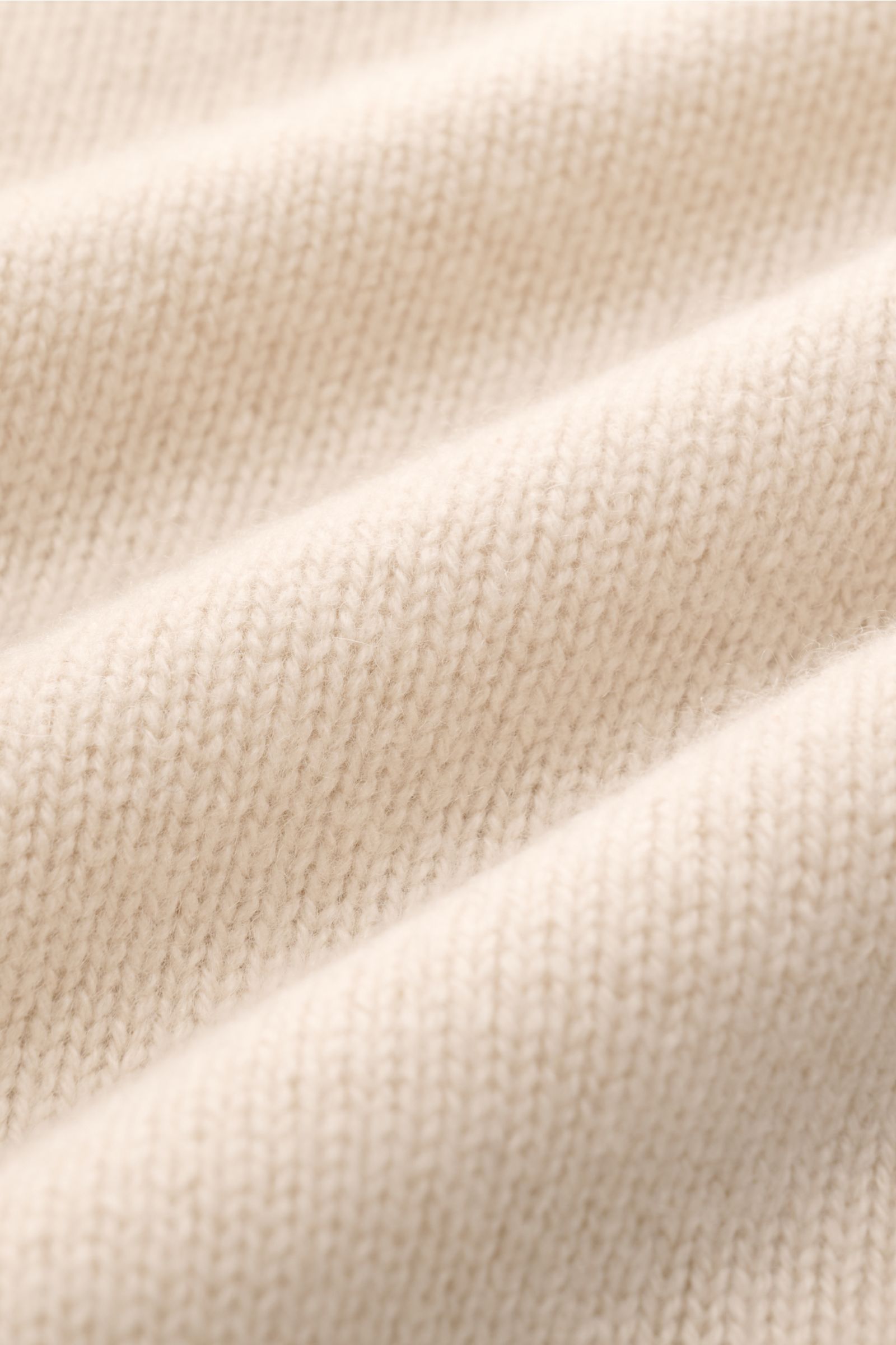 Close-up front view of Soft Goat Cashmere cardigan sand showing the medium-fine knit, soft texture, and wide ribbed bands. Sustainably produced and certified: Young label SOFT GOAT shows how it’s done with their incredibly soft cashmere cardigan in shirt 