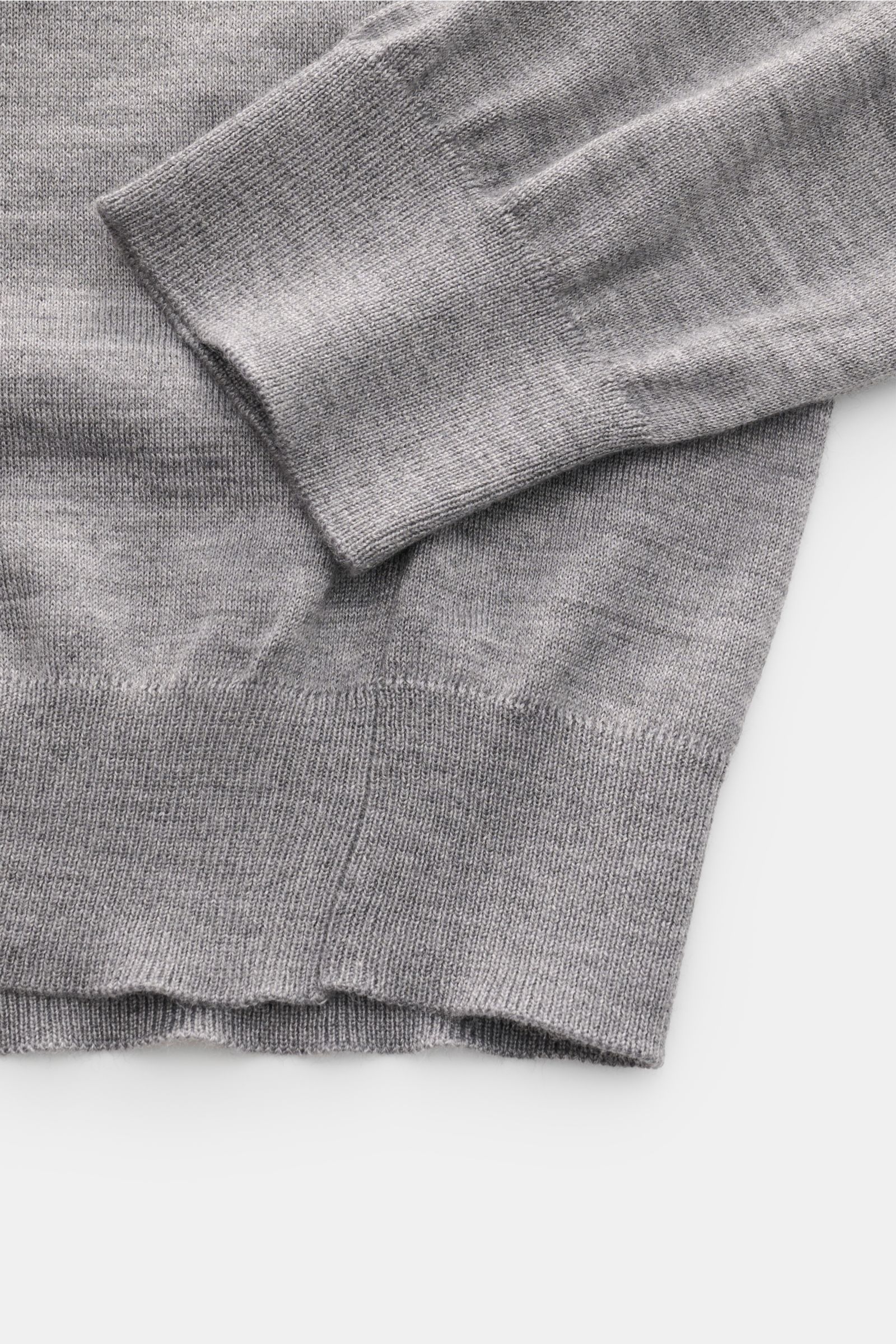 Close-up view of the cuff and hem of the Malo Knit polo grey melange, showing its fine knit and ribbed bands.

Description:  
An everyday essential: This soft knit polo by MALO is made of fine fabric in cashmere and silk – a stylish piece for classic l