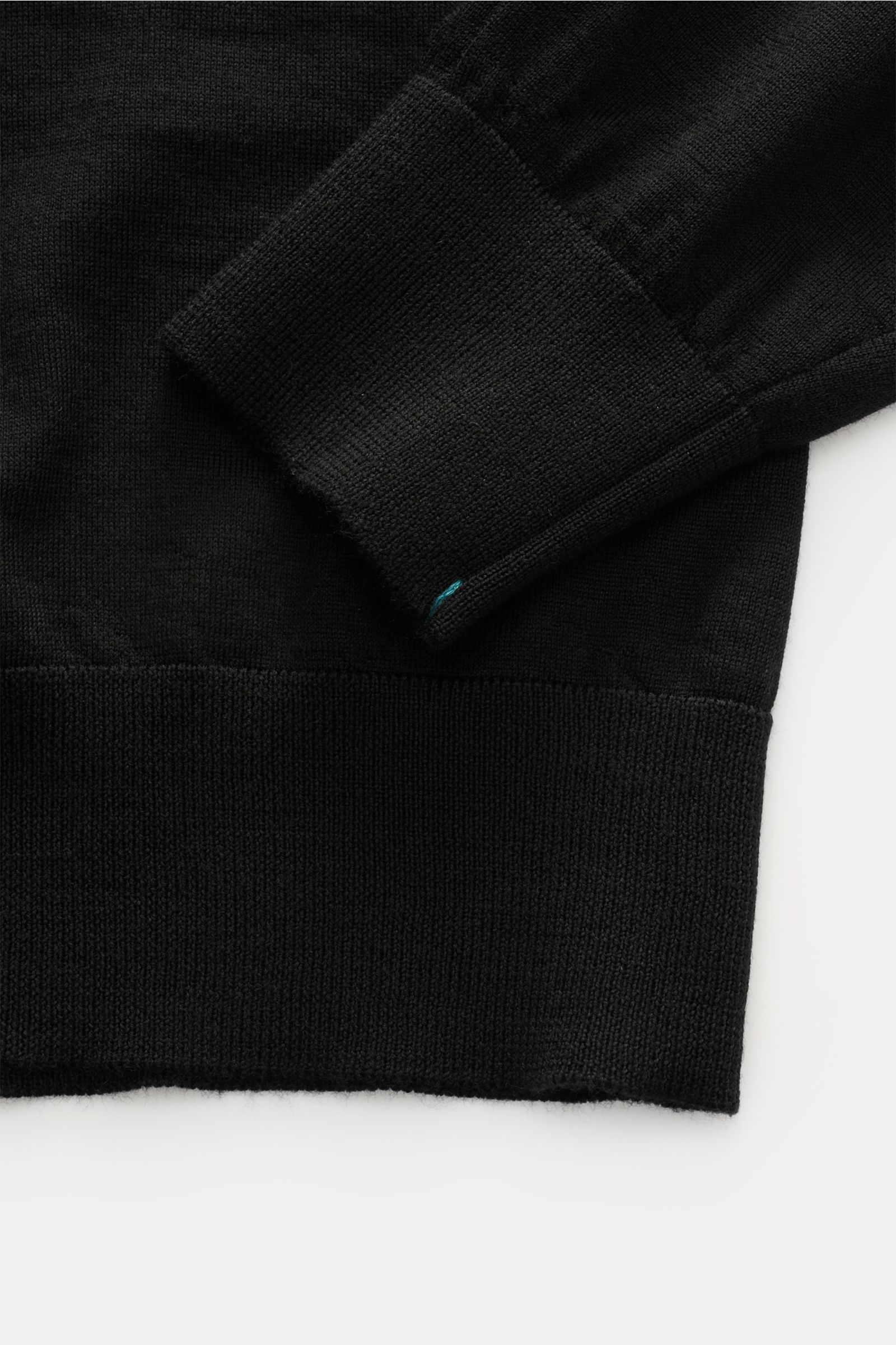 Fioroni Strickpolo schwarz, Detailaufnahme von Ärmel und Bund, reine Wolle, weicher Griff, feines Strickbild, Rippbündchen, Regular Fit.