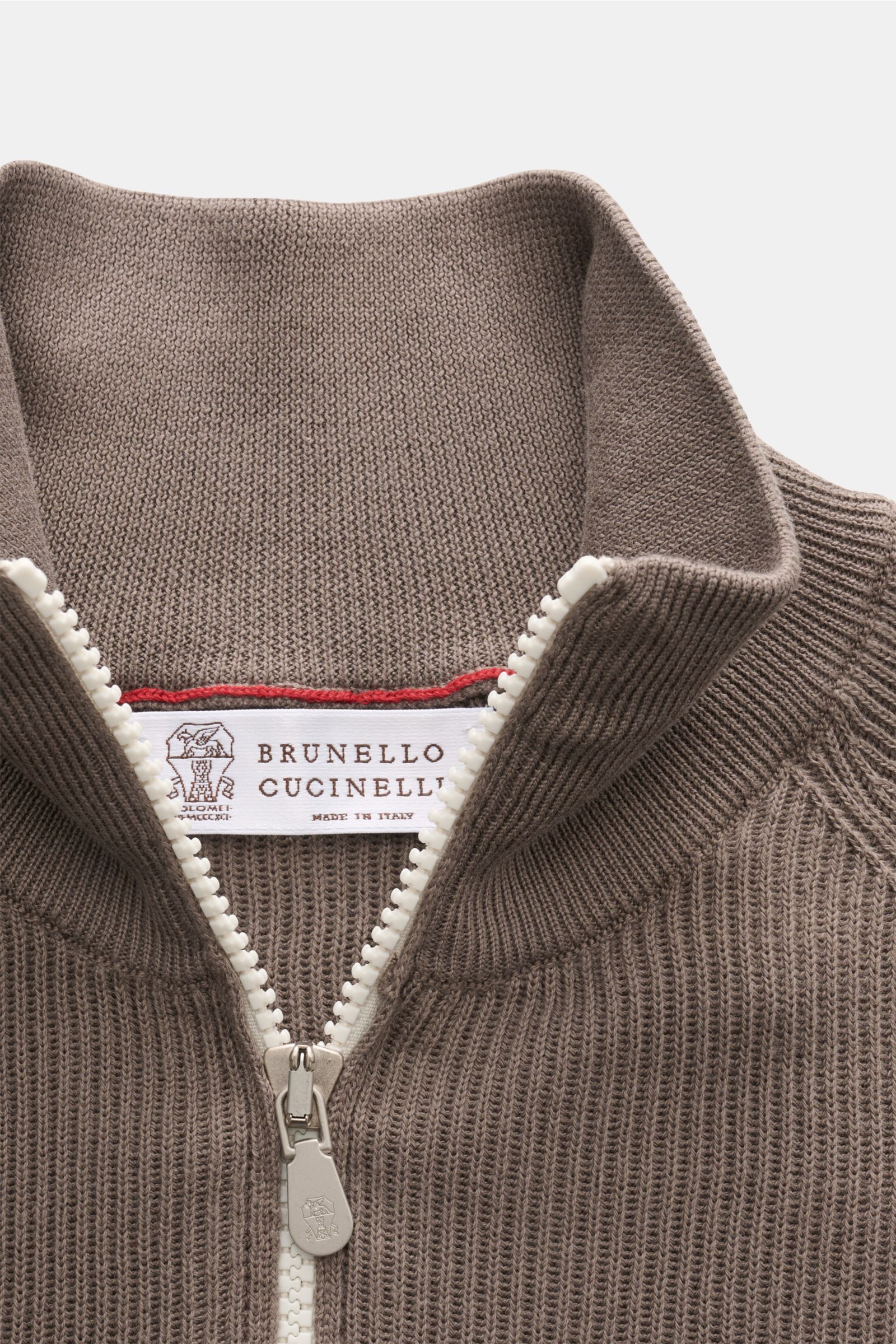 Close-up top-down view of Brunello Cucinelli Troyer taupe knit collar with zipper, showcasing fine cotton knit, soft touch, and contrast edges.

Casual-Eleganz auf höchstem Niveau: Der Troyer von BRUNELLO CUCINELLI aus edler Baumwollqualität überzeugt 