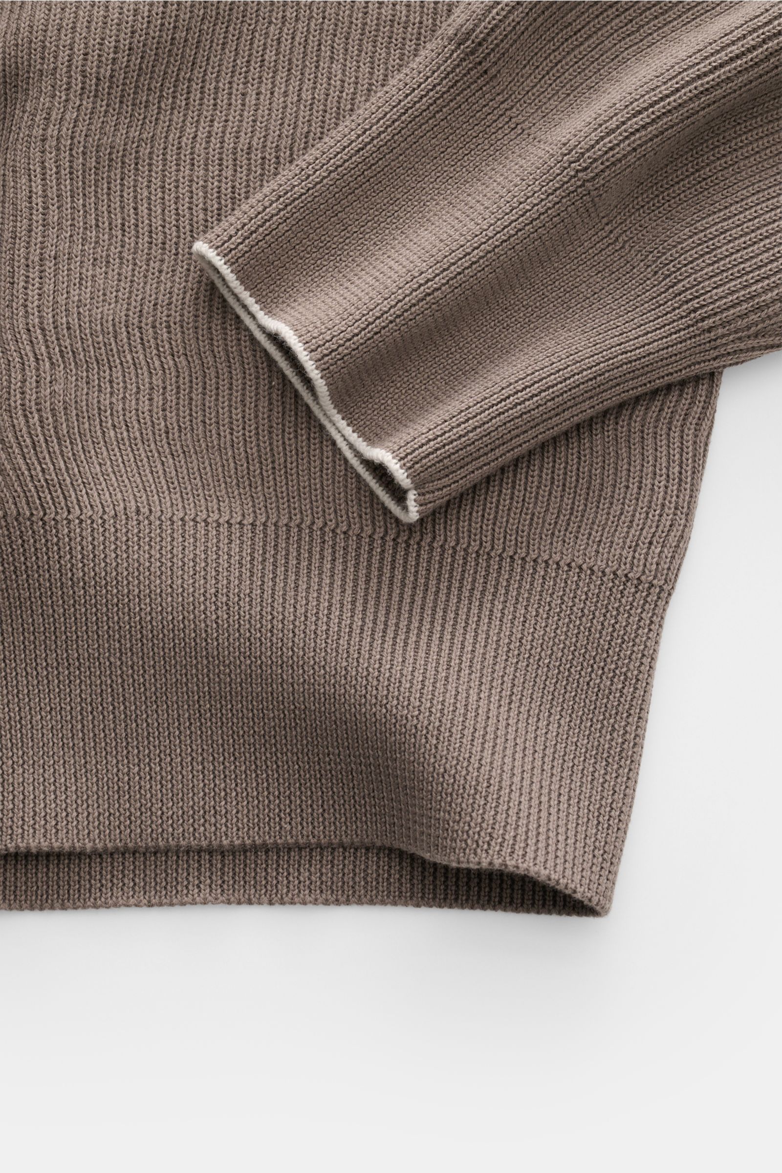 Close-up side view of the Brunello Cucinelli Troyer taupe showing fine knit texture, soft cotton fabric, and ribbed cuffs with contrast edges.

Casual-Eleganz auf höchstem Niveau: Der Troyer von BRUNELLO CUCINELLI aus edler Baumwollqualität überzeugt m