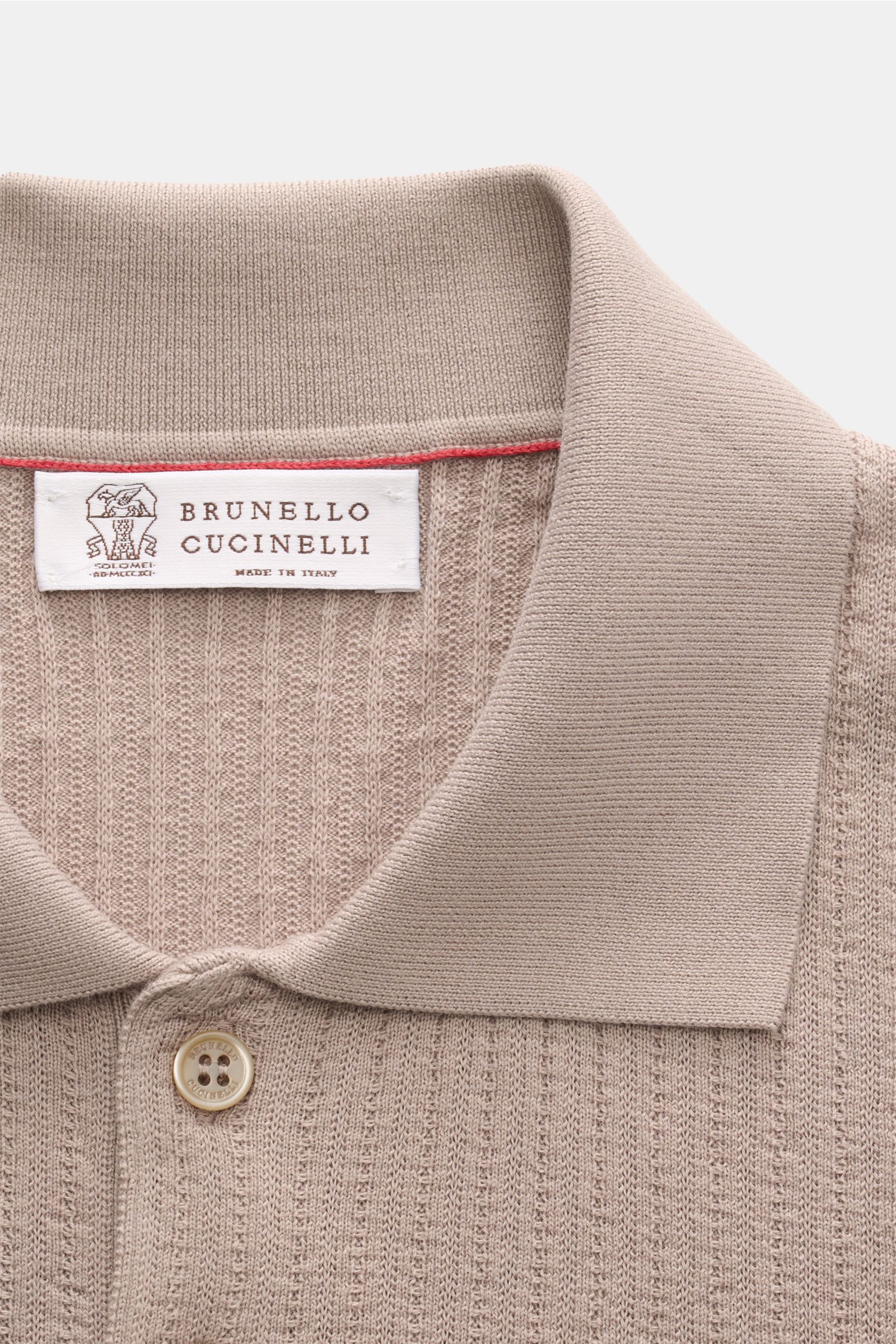 Close-up front view of Brunello Cucinelli Kurzarm-Strickpolo taupe showing classic collar, button, and ribbed cotton knit texture. Für souveräne Alltags-Eleganz: Das zeitlose Kurzarm-Strickpolo von BRUNELLO CUCINELLI überzeugt mit feinster, leichter Baumw