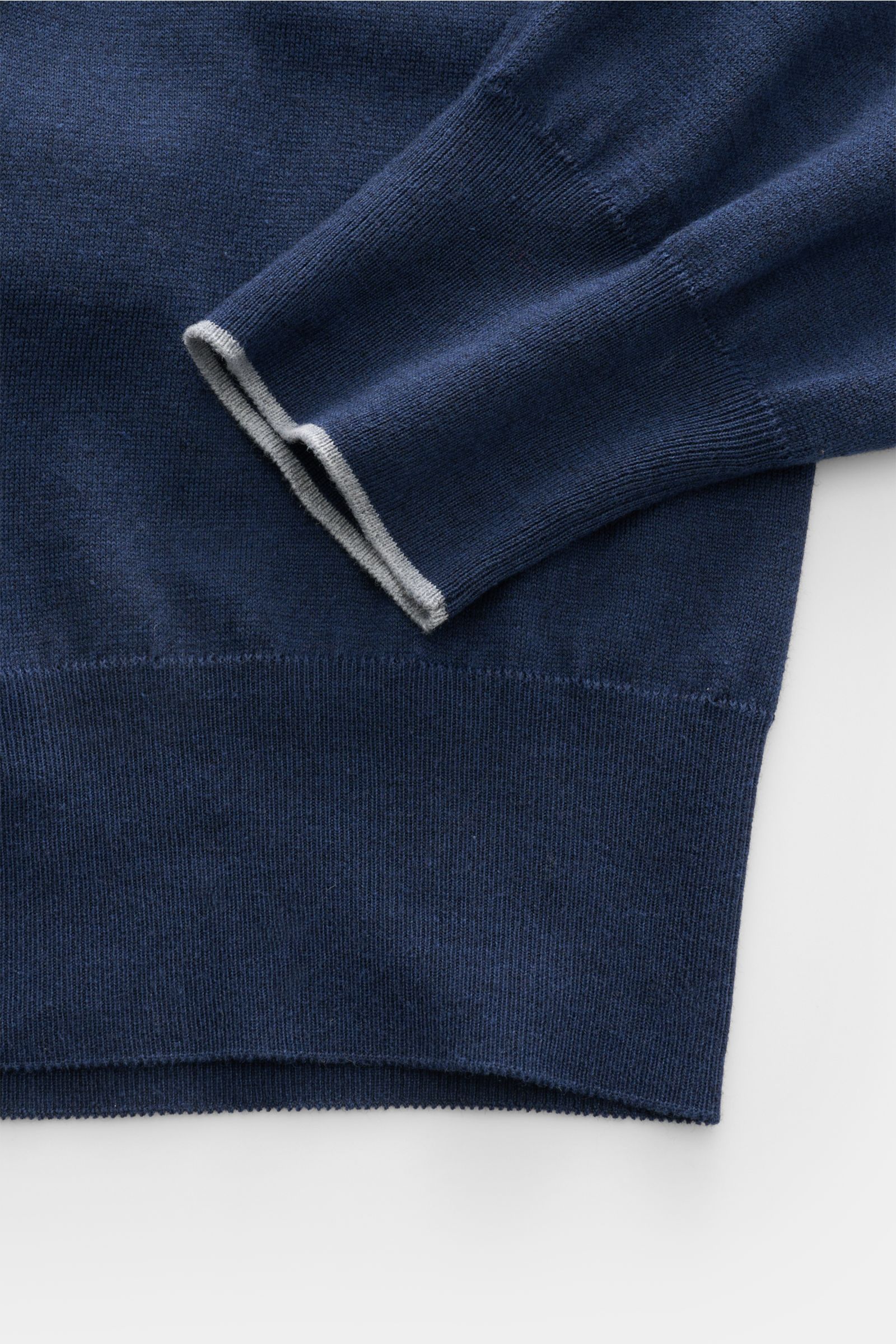Close-up of the navy sleeve and hem of the Brunello Cucinelli Troyer navy, photographed from above showing fine knit texture and contrast edge.

Description: Sportives Freizeit-Essential von höchster Raffinesse: Der Troyer von BRUNELLO CUCINELLI aus ex