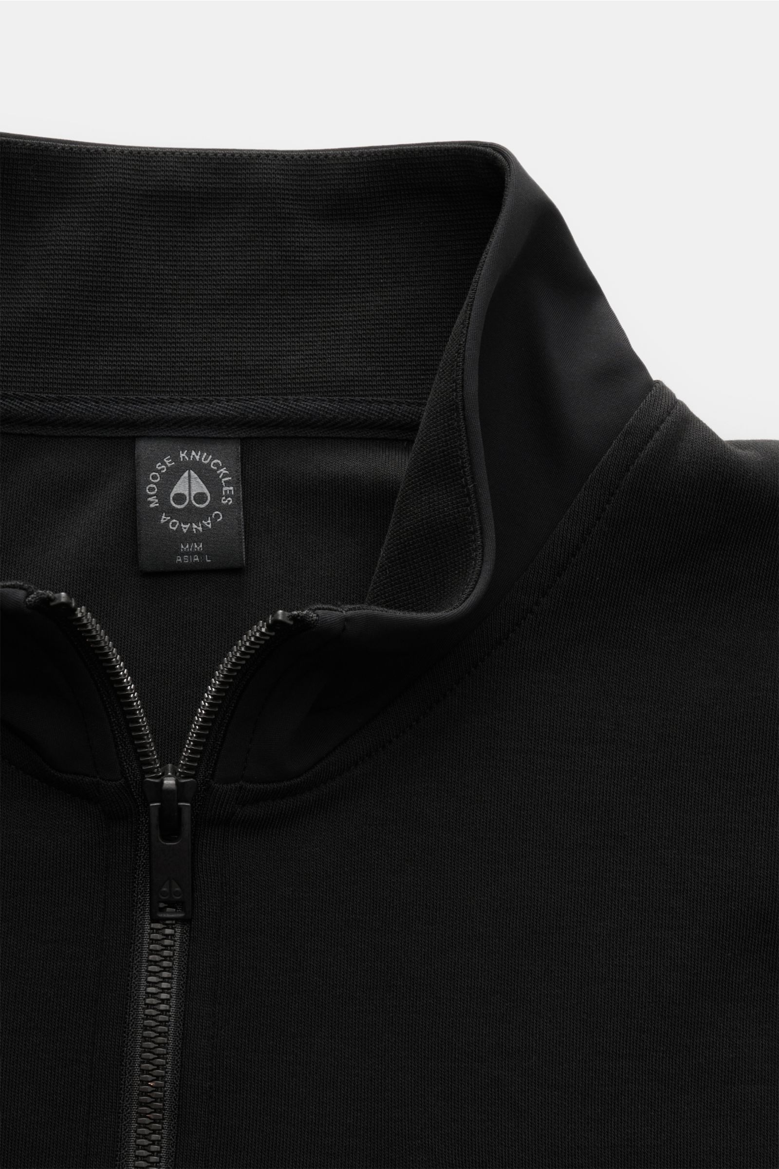 Close-up front view of the black Moose Knuckles Sweat-Troyer 'Dalon' schwarz showing a high collar with zipper and label inside collar.

Sportiv durch den Herbst: Der Sweat-Troyer von MOOSE KNUCKLES überzeugt als vielseitiges Basic für legere Looks.