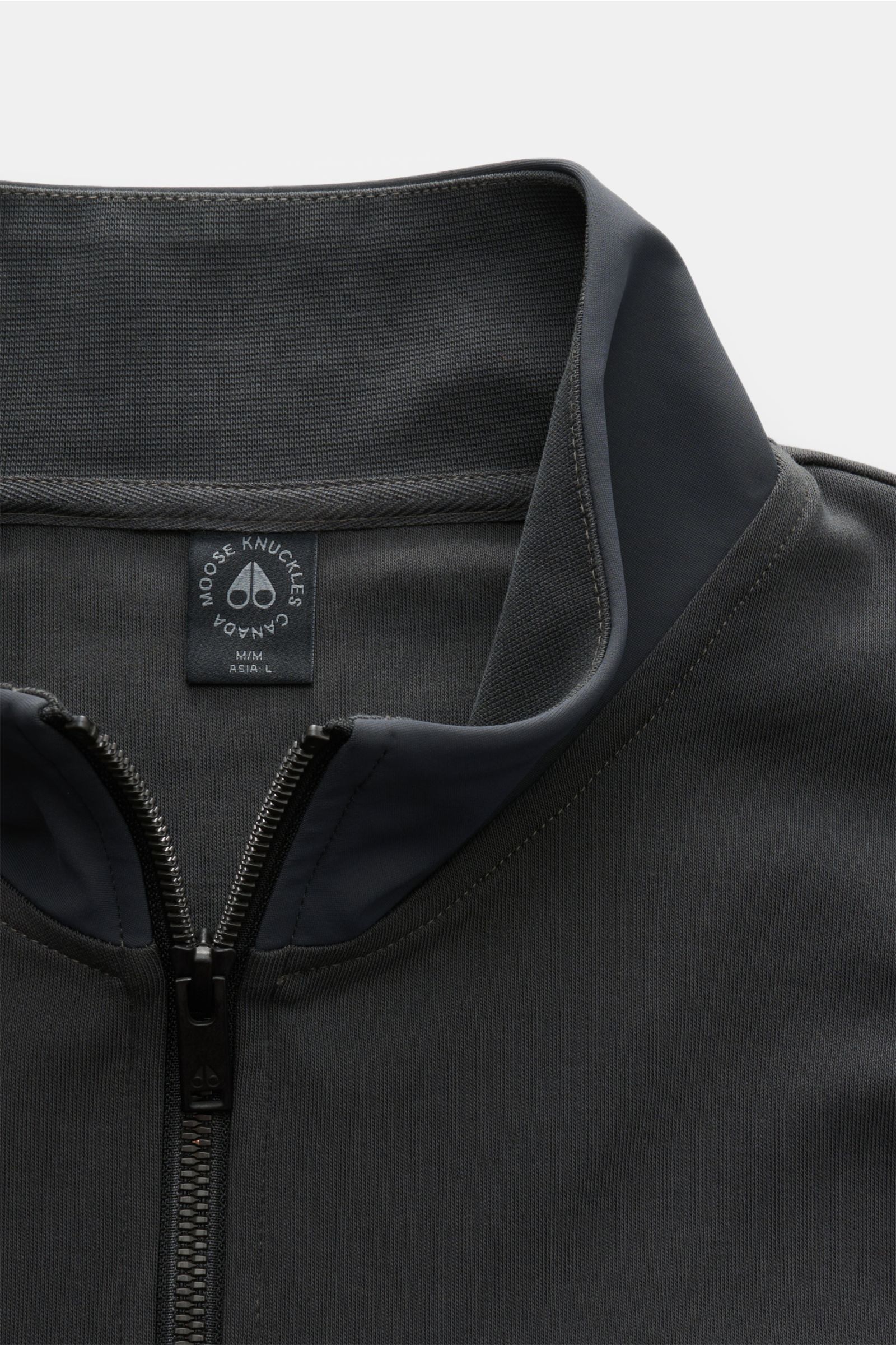 Moose Knuckles Sweat-Troyer 'Dalon' graugrün, nah fotografiert von oben, Baumwolle, Nylon-Einsätze, hoher Kragen mit Zipper, Brusttasche mit Metall-Logo, Regular Fit, elastische Rippbündchen, sportiv für den Herbst.