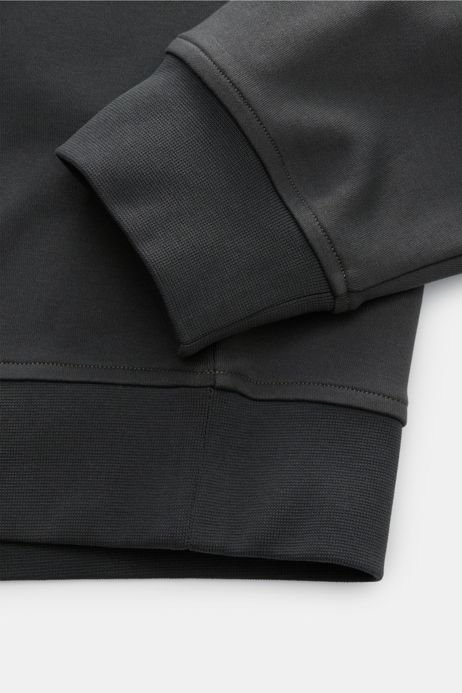 Nahaufnahme des Ärmel- und Saumabschlusses des Moose Knuckles Sweat-Troyer 'Dalon' graugrün, aus reiner Baumwolle mit elastischen Rippbündchen, fotografiert von oben. Sportiv durch den Herbst: Der Sweat-Troyer von MOOSE KNUCKLES überzeugt als vielseitiges