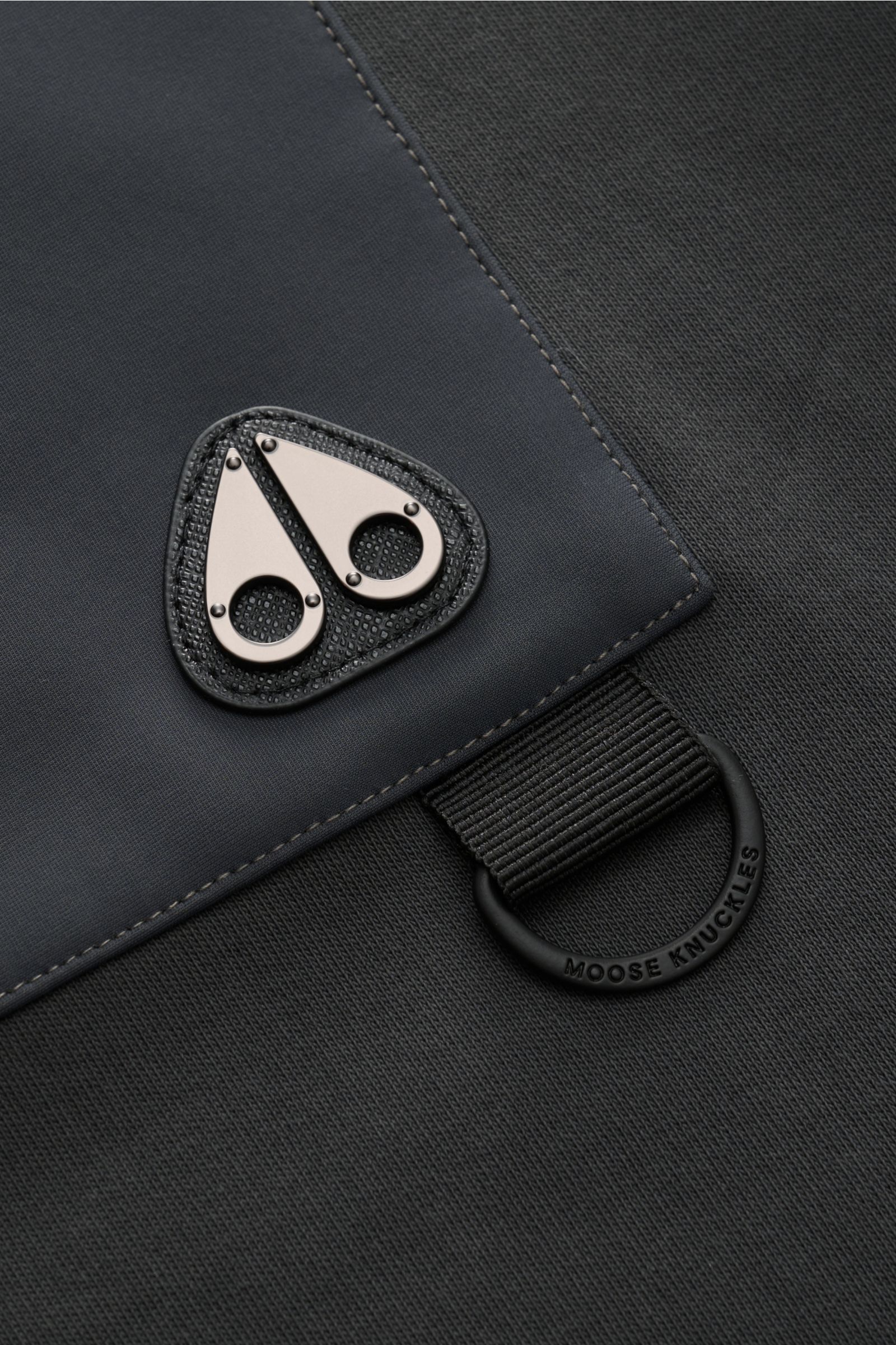 Detailaufnahme des Moose Knuckles Sweat-Troyer 'Dalon' graugrün mit Metall-Logo und Nylon-Einsatz an Brusttasche, elastischen Rippbündchen, aus schräger Perspektive. Sportiv durch den Herbst: Sweat aus reiner Baumwolle, weicher Griff, Regular Fit, hoch sc