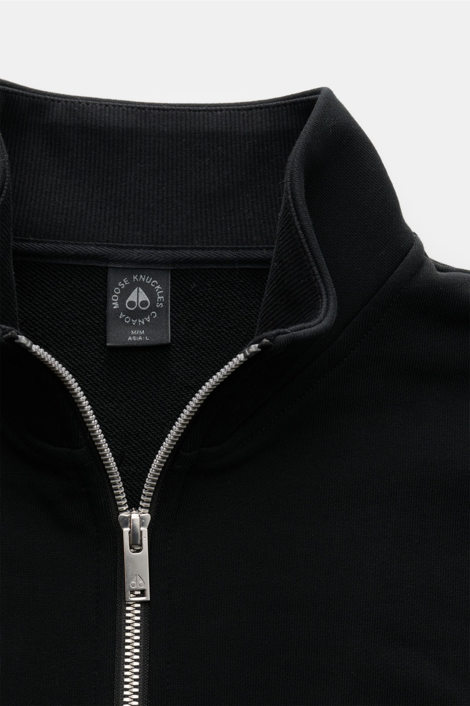 Moose Knuckles Sweat-Troyer 'Hartsfield' schwarz, von oben fotografiert, aus reiner Baumwolle mit weichem Griff, Regular Fit, hoch schließendem Kragen mit Zipper, Metall-Logo am Oberarm und elastischen Rippbündchen.