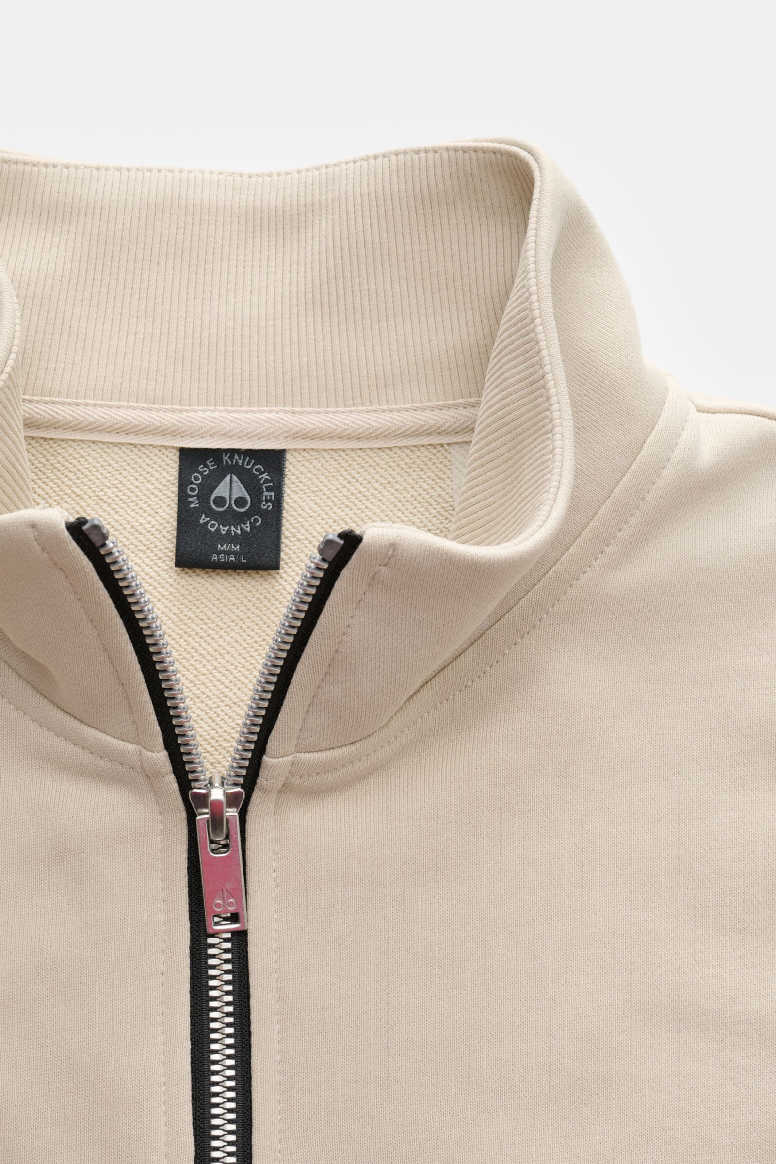 Moose Knuckles Sweat-Troyer 'Hartsfield' creme, Detailansicht von oben, reine Baumwolle, weicher Griff, Regular Fit, hoher Kragen mit Zipper, Metall-Logo am Oberarm, elastische Rippbündchen.