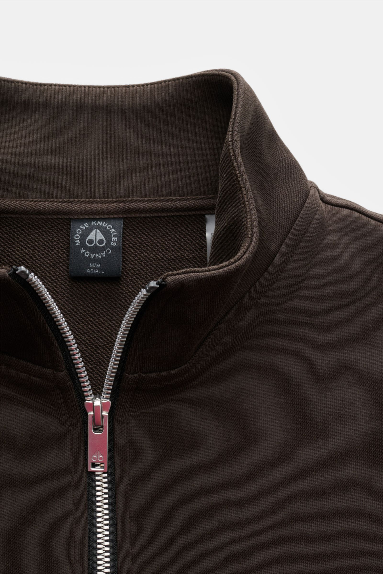 Moose Knuckles Sweat-Troyer 'Hartsfield' graubraun, aus reiner Baumwolle, weicher Griff, Regular Fit, hoch schließender Kragen mit Zipper, Metall-Logo am Oberarm, elastische Rippbündchen, Nahaufnahme von oben.