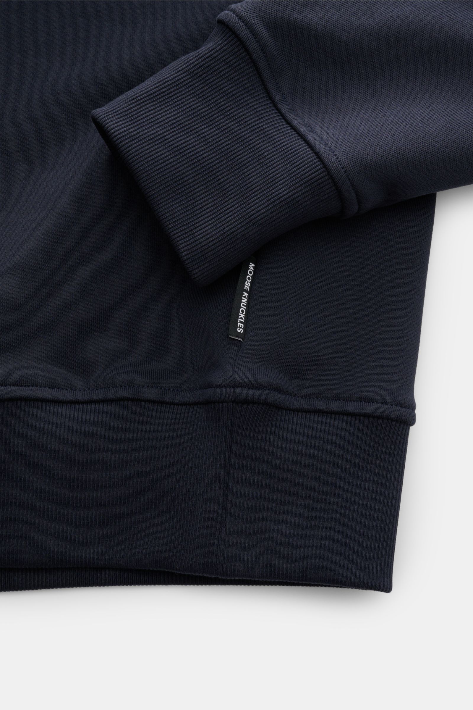 Moose Knuckles Sweat-Troyer 'Hartsfield' navy shown in close-up from the side, highlighting ribbed cuffs and hem, soft cotton fabric, and brand label. Leger durch den Herbst: Der Sweat-Troyer von MOOSE KNUCKLES überzeugt als vielseitiges Basic für sportiv