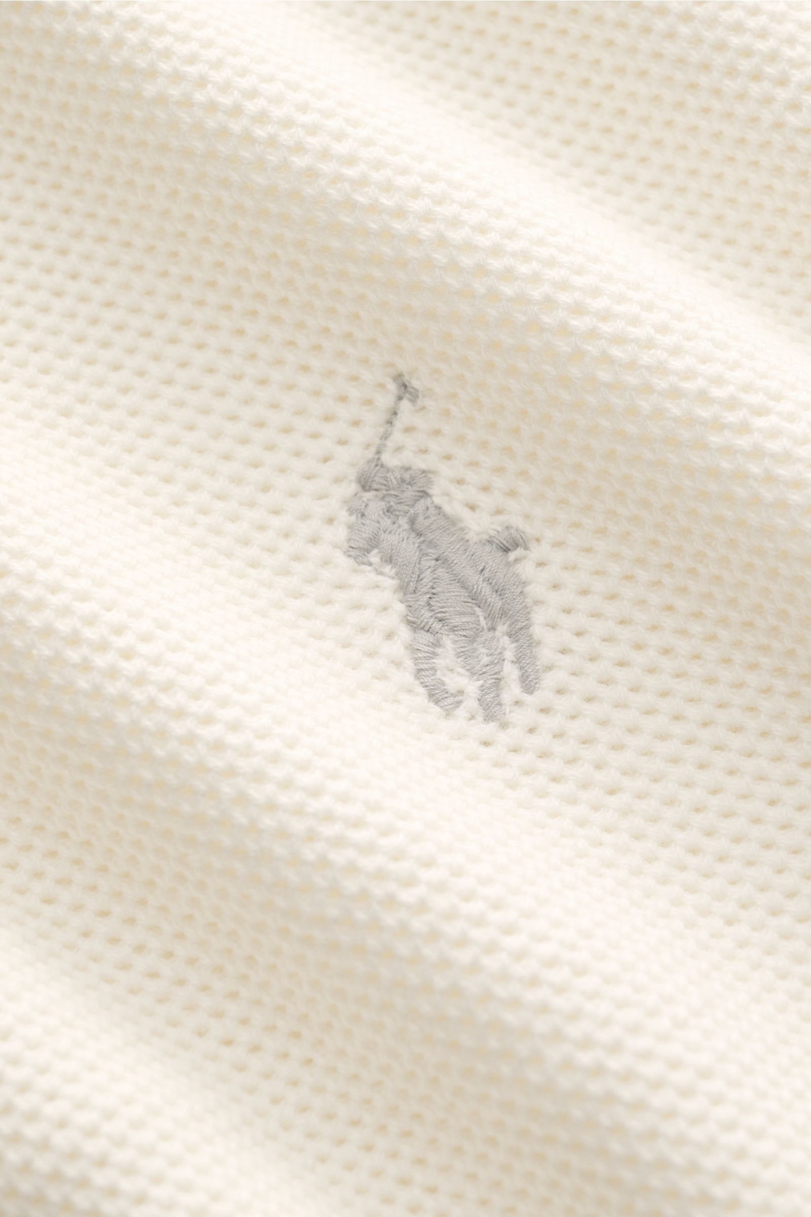 Detailaufnahme des Polo Ralph Lauren Troyer offwhite aus reiner Baumwolle mit feinem Strukturstrick und Polospieler-Stitching, Nahaufnahme.