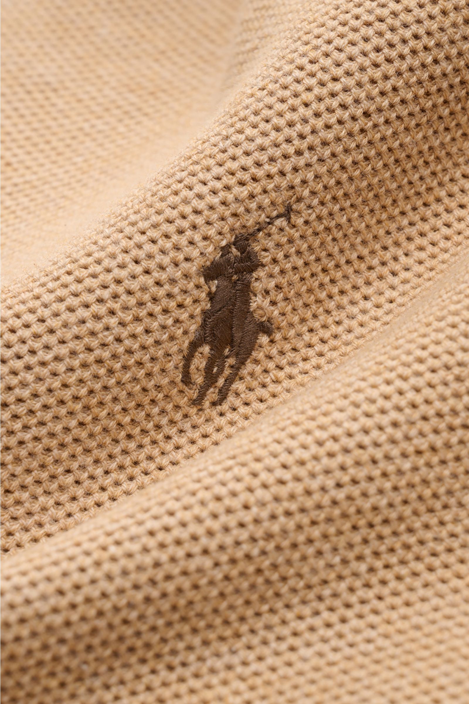 Nahaufnahme des tonalen Polospieler-Stitchings auf der Brust eines Polo Ralph Lauren Troyer camel meliert aus reiner Baumwolle mit mittelfeinem Strickbild.