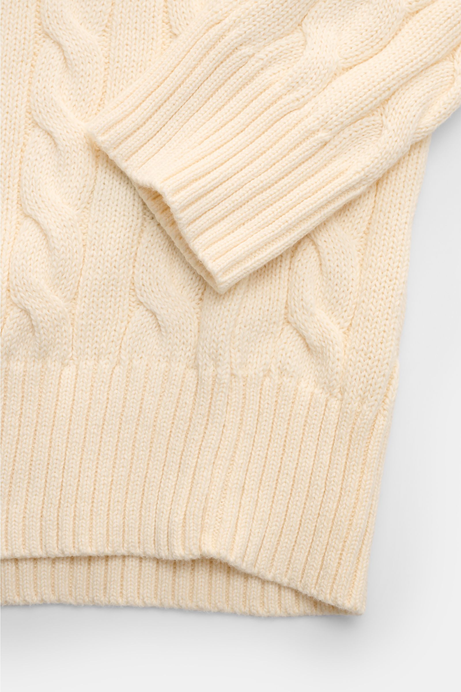 Cremefarbener Polo Ralph Lauren Troyer im Slim Fit mit Zopfstrickmuster, Rippbündchen, Troyer-Kragen und Polospieler-Stitching, detailnah von oben.