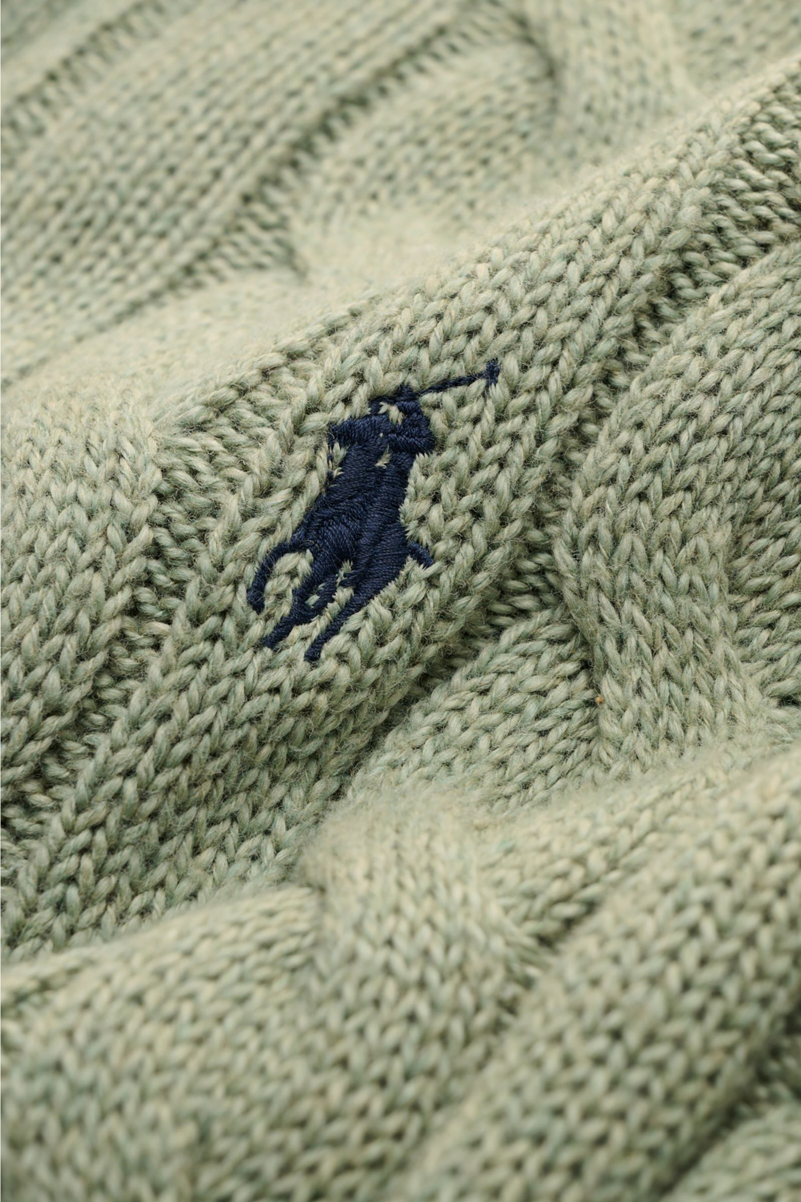 Nahaufnahme des mintgrünen Polo Ralph Lauren Troyers mit Zopfstrickmuster und kontrastierendem Polospieler-Stitching auf weichem Baumwollstrick.