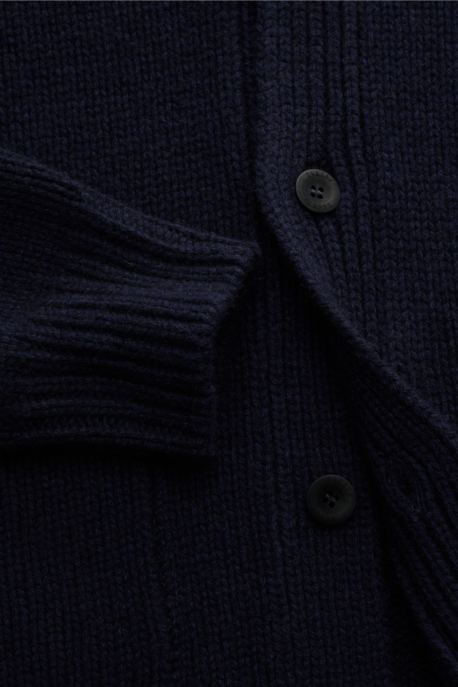 Nahaufnahme des 04651/ A trip in a bag Cashmere Cardigan navy mit grobem Strickbild, reiner Cashmere, Slim Fit, V-Ausschnitt, Vier-Knopf-Leiste, aufgesetzten Hüfttaschen und komfortablen Rippbündchen, sehr weicher Griff sichtbar.
