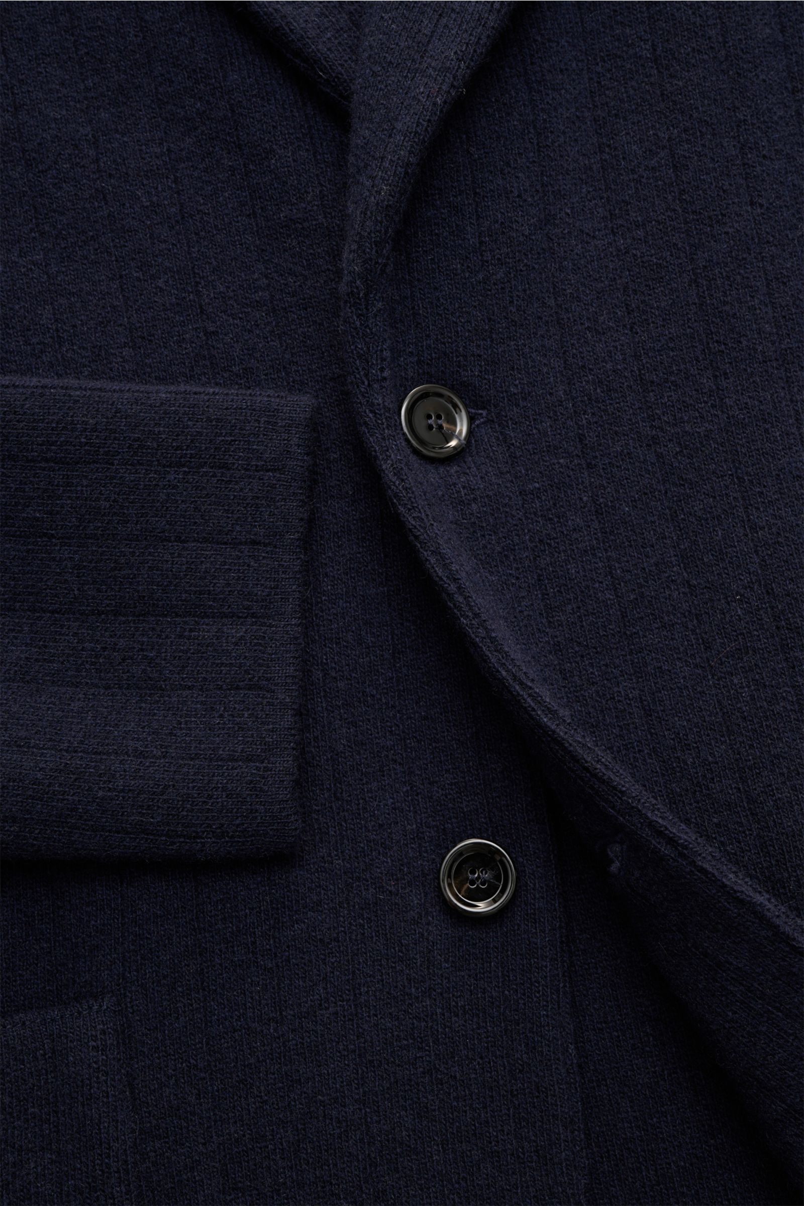 Nahaufnahme des taillierten Lardini Strickblazer navy aus Wolle-Cashmere mit weichem Griff, breiter Rippe, zwei Knöpfen und Blütenpin am Revers.