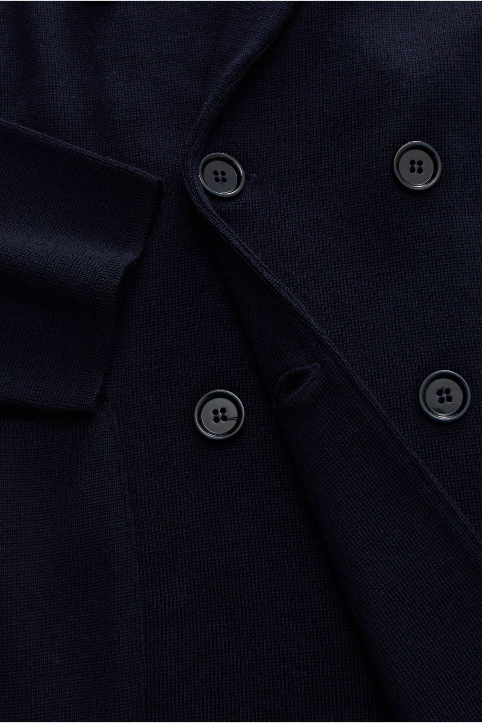 Nahaufnahme des Lardini Strickblazer navy in Slim Fit, zweireihig mit drei Knöpfen, Revers mit Blütenpin, aus weicher reiner Wolle.