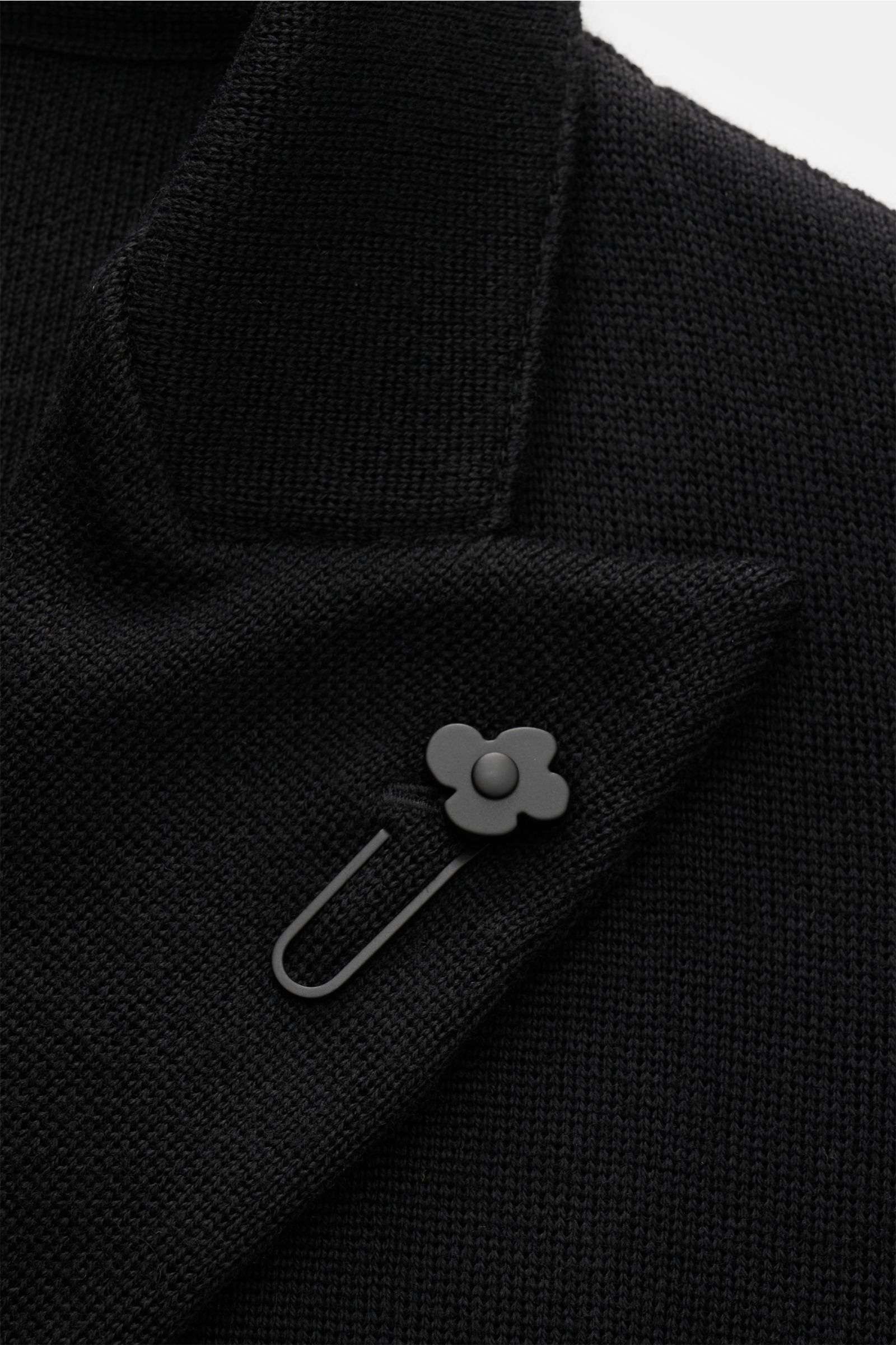 Close-up front view of the Lardini Strickblazer schwarz showing the finely knitted pure wool fabric, classic slim fit, two-row three-button style, soft texture, lapel with flower pin, rear side vents, and patch hip pockets. Mit klassischer Silhouette u