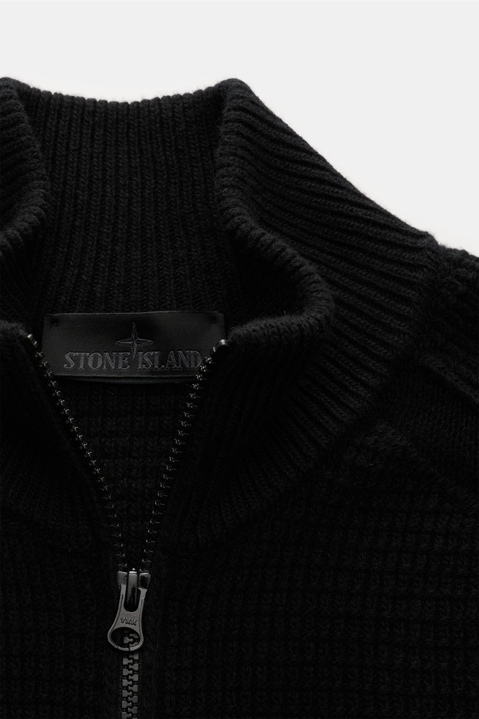 Stone Island Strickjacke 'Ghost Piece' schwarz shown in close-up from the front, highlighting the high collar, tonal compass badge, and textured knit. Vielseitiges Winter-Essential: Die Strickjacke aus der Ghost-Kollektion von STONE ISLAND bietet zahlreic