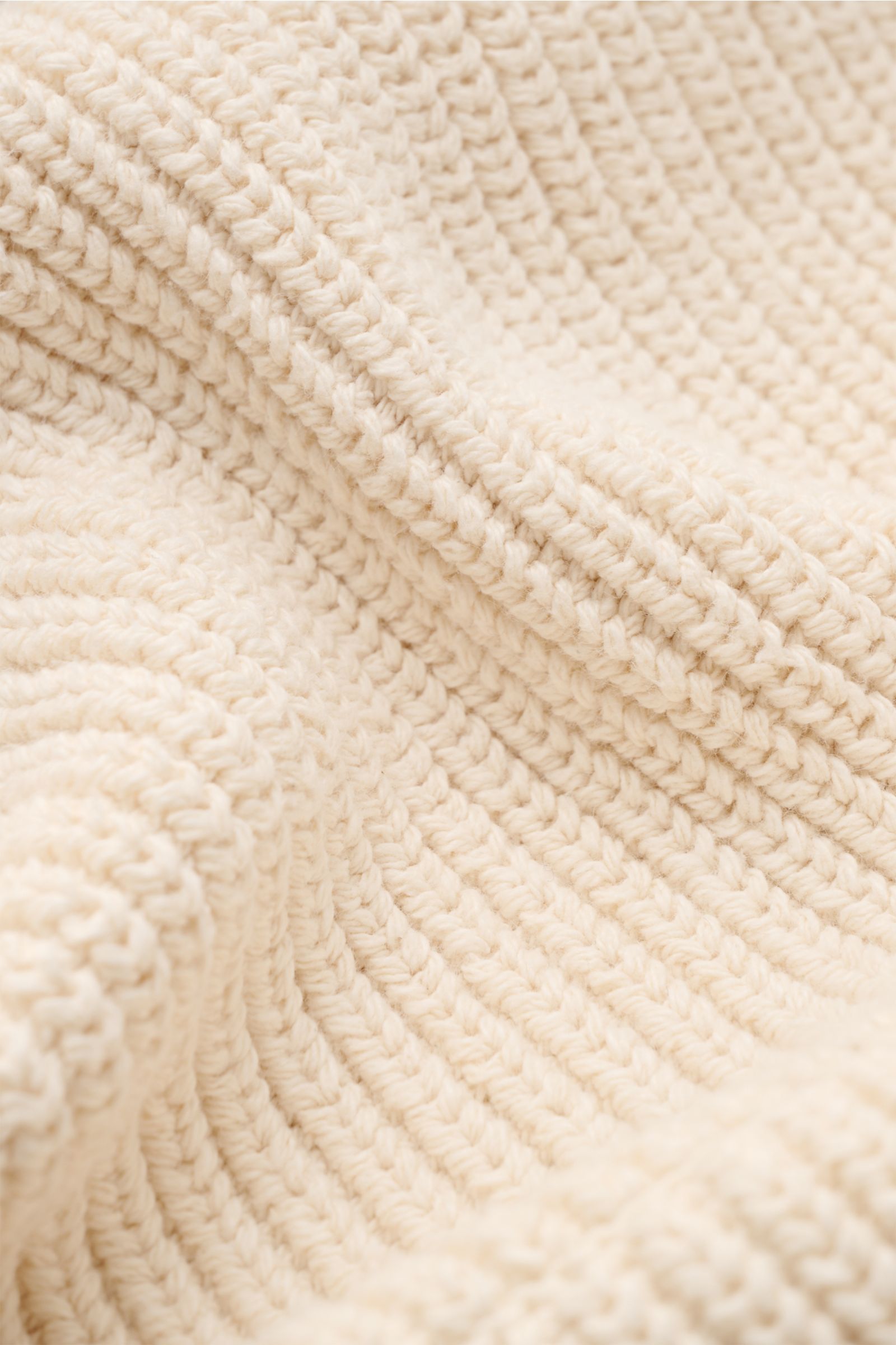 Close-up, angled view of Stone Island Strickjacke 'Raw Beauty' creme showing detailed patent knit texture in pure cotton, highlighting structured, medium-coarse knit.  
Ein Essential für moderne Casual-Looks: Diese Strickjacke von STONE ISLAND überzeug