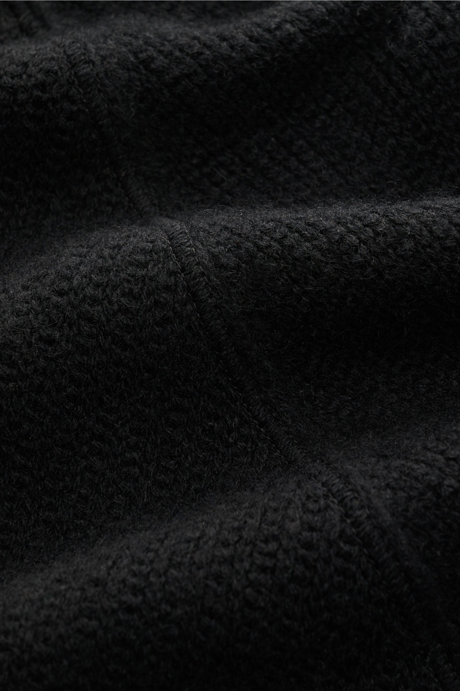 Stone Island Cashmere Strickjacke 'Ghost Piece' schwarz, Detailaufnahme des mittelfeinen Strickbilds und markanter Overlock-Nähte.