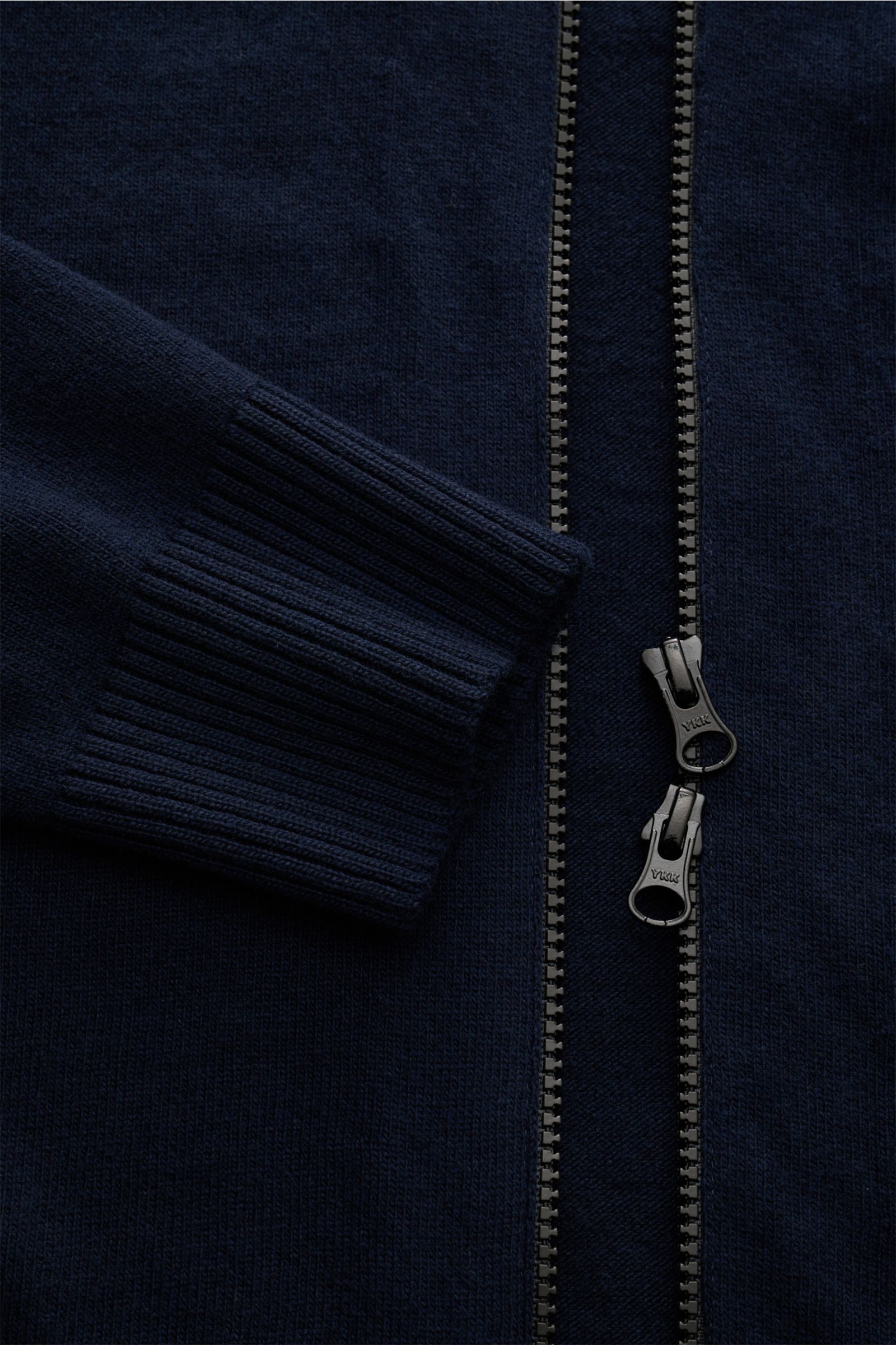 Stone Island Strickjacke navy aus zertifizierter Geelong-Schurwolle, Detailaufnahme von Ärmel und robustem Zwei-Wege-Reißverschluss, weicher Griff, Slim Fit, Raglanärmel, Stehkragen, Kompass-Badge am Ärmel, Rippbündchen.
