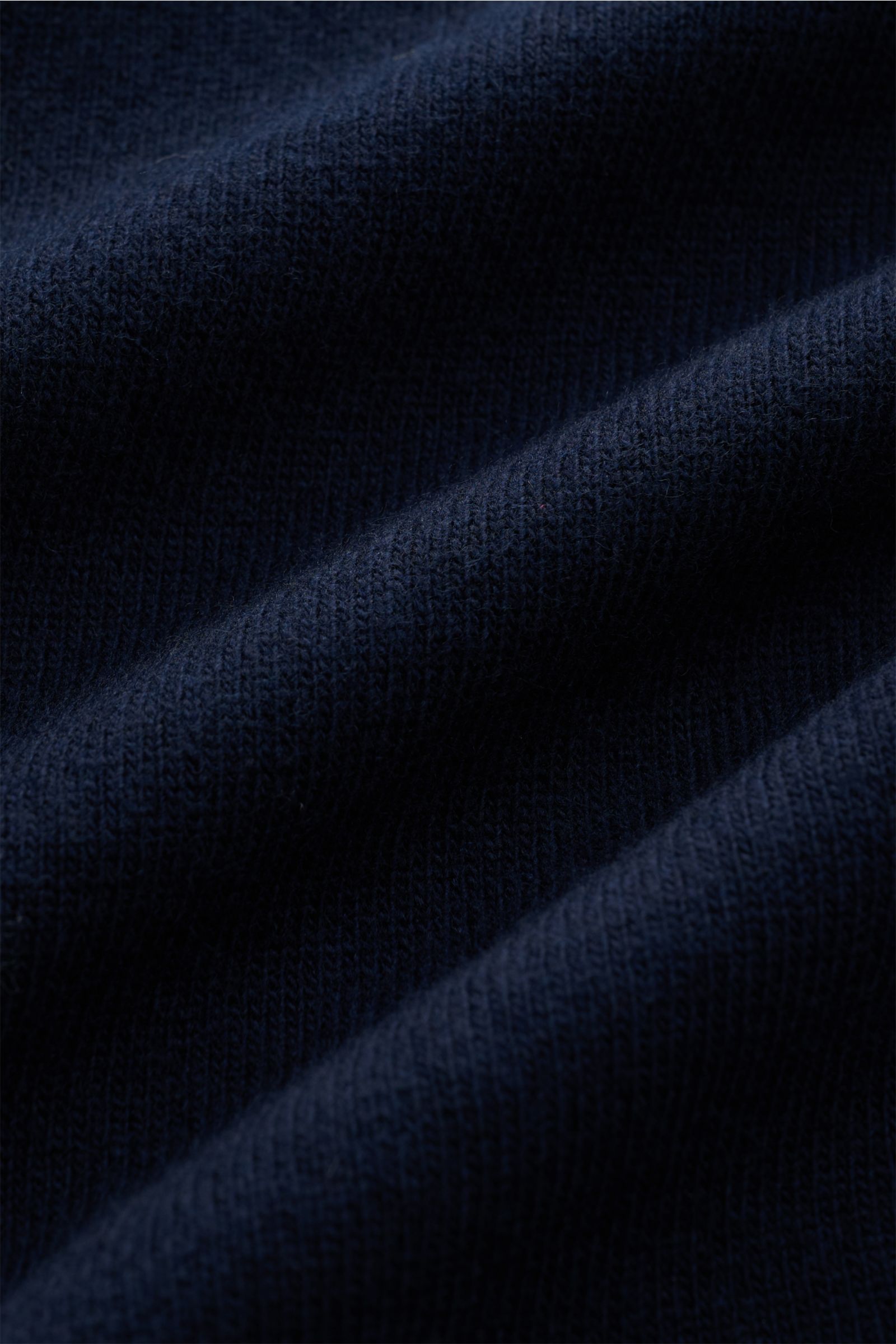 Stone Island Strickjacke navy aus zertifizierter Geelong-Schurwolle in feiner Jersey-Qualität, Detailaufnahme des weichen, strukturierten Stoffes.