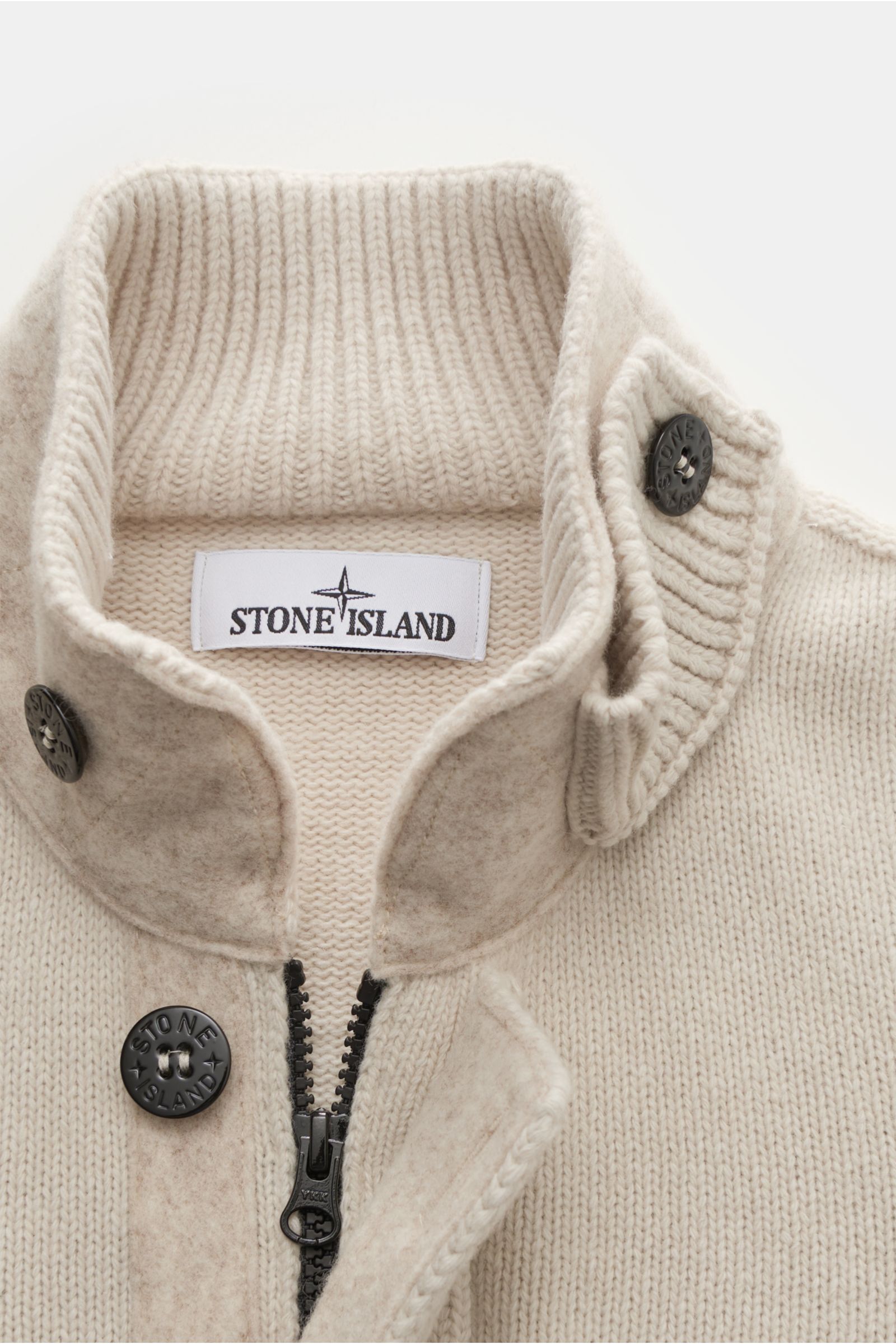 Stone Island Strickjacke 'Lambswool' sand in Nahaufnahme von oben, weicher Wollmix mit Linksstrick, Filz-Details, markanten Knöpfen und Zipper.