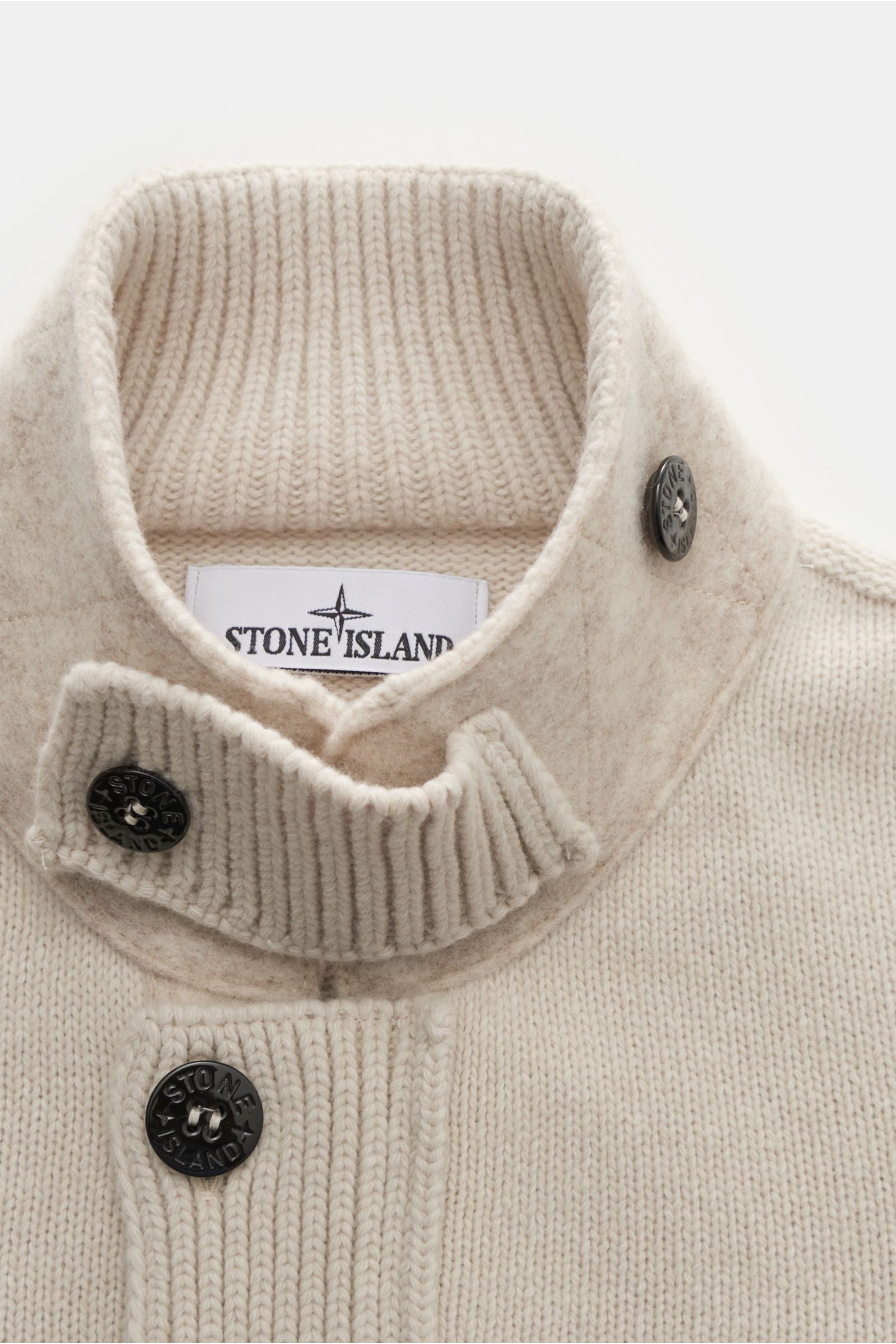 Stone Island Strickjacke 'Lambswool' sand, Nahaufnahme von oben, Wollmix mit Linksstrick, Filz-Details, markanten Knöpfen und Stehkragen mit Knopfriegel.