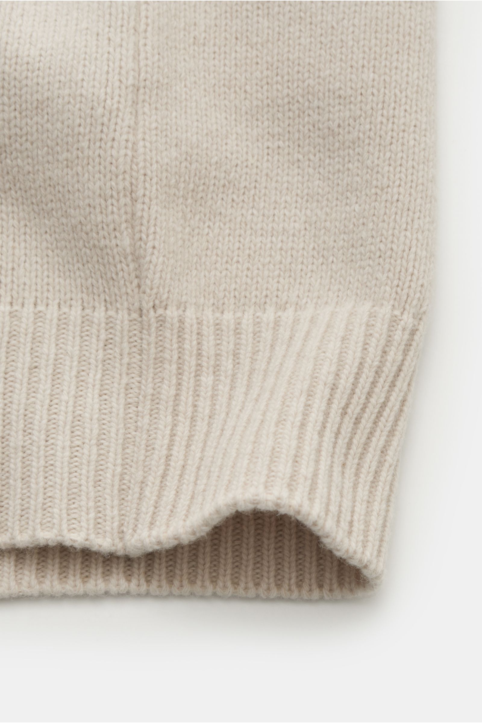 Nahaufnahme der elastischen Rippbündchen der Stone Island Strickjacke 'Lambswool' sand aus weichem Wollmix, seitliche Ansicht.